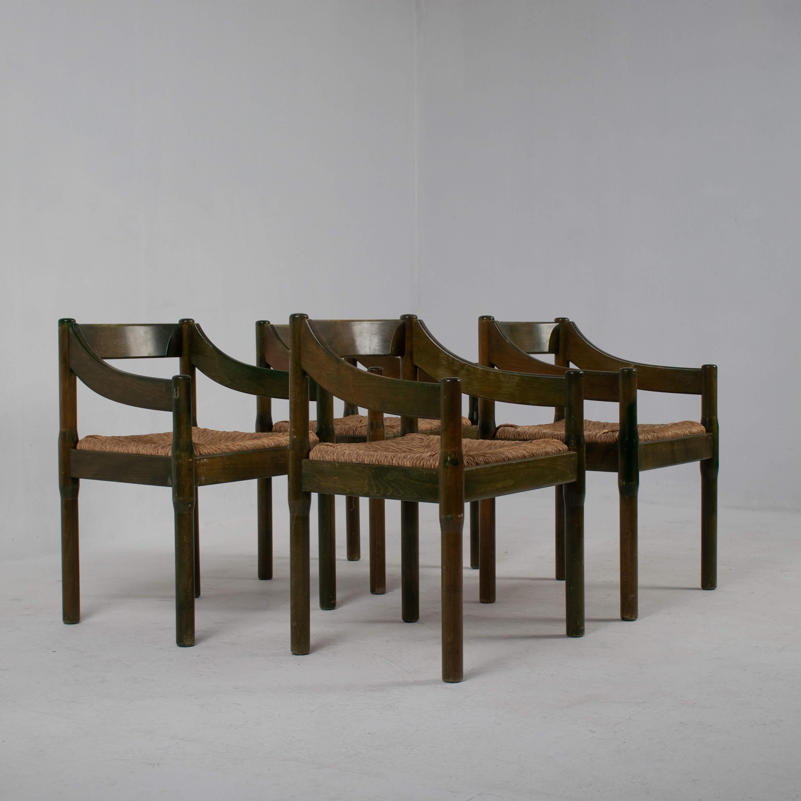 Set of 4 vintage Carimate armchairs designed by Vico Magistretti for Cassina, Italy, 1970s. These chairs feature a sleek design with green lacquered wooden frames, offering a bold and modern aesthetic. The simple yet elegant lines of the Carimate