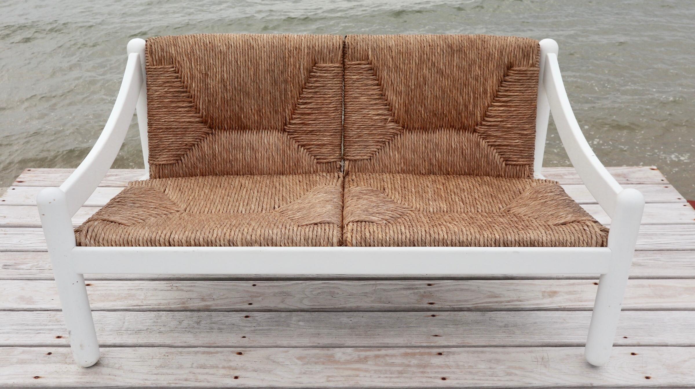 Elegant “Carimate” loveseat by Vico Magistretti for Cassina. Solid wood frame with rush cushions. Very comfortable and sturdy yet airy and easy to move around perfect for a sun porch or summer/country home. Seats 2 comfortably. In original