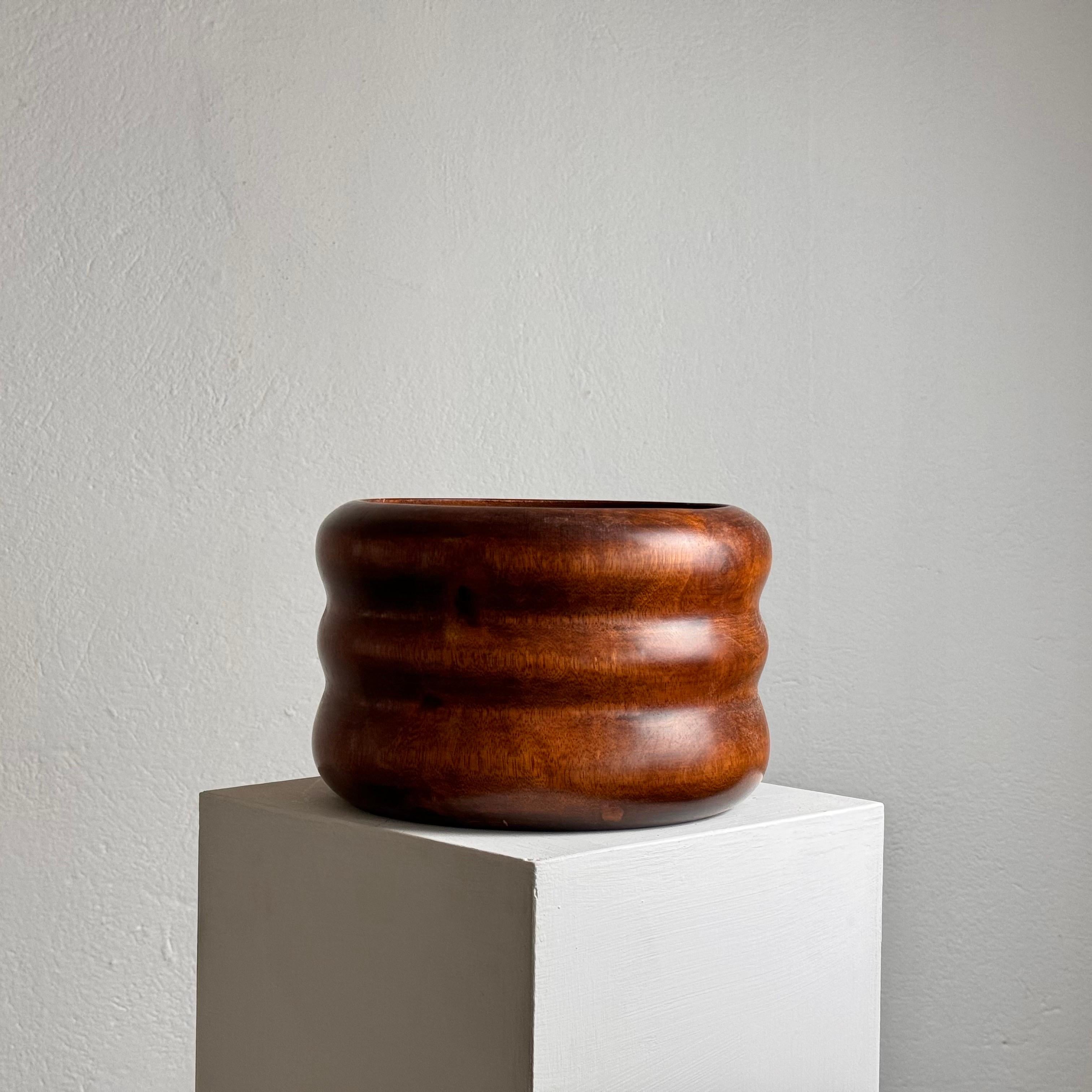This exquisite decorative vase was crafted by artist Carine Tontini in the 1990s as part of her Extrem Origin Collection. The vase is carved from a single piece of exotic palm wood, showcasing a smooth and varnished finish that highlights the