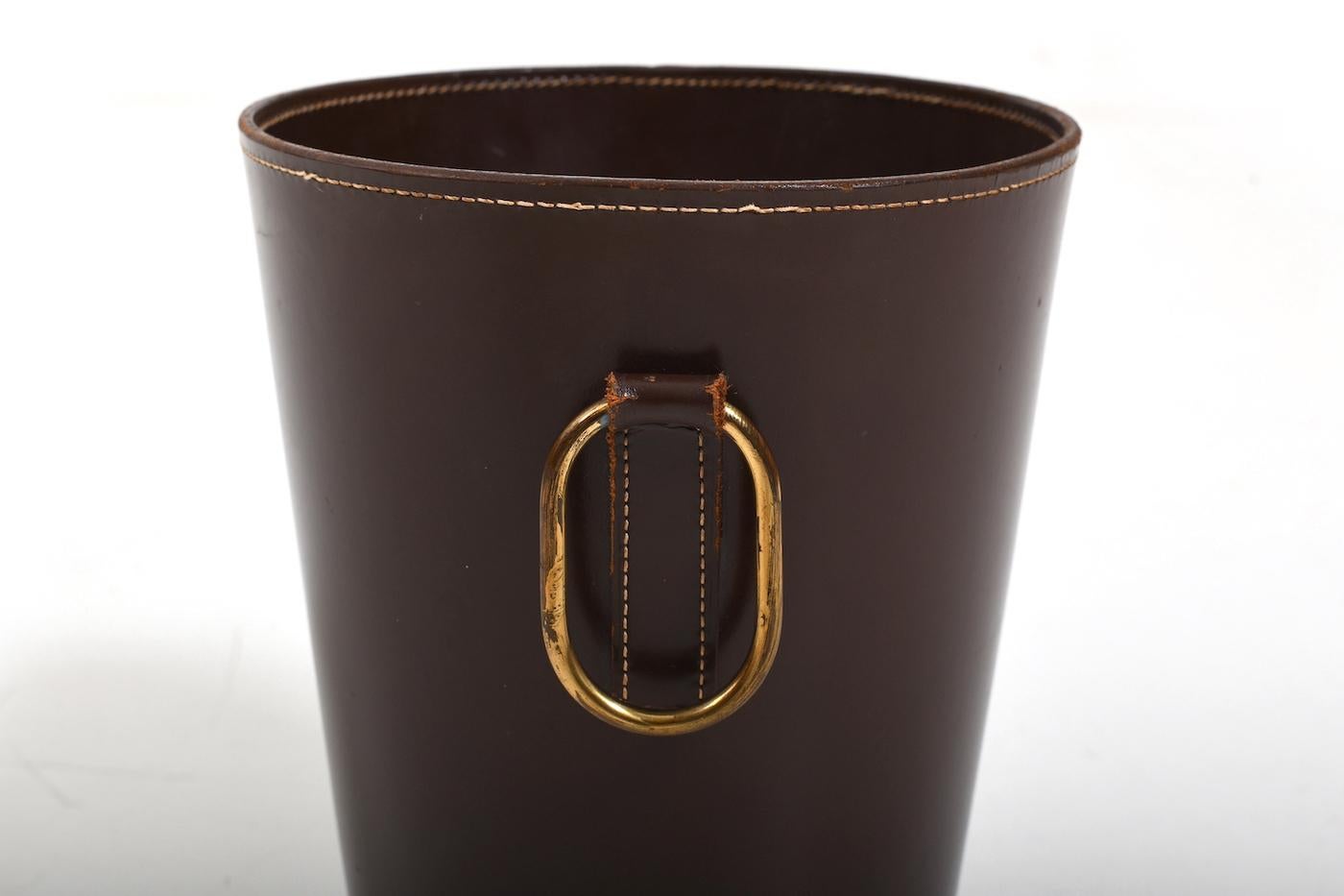 Mid century Carl Auböck waste paper basket for Illums Bolighus 1950s. Made in darker brown core leather and with brass handle. Beautiful old patina. In very good vintage condition, with minor signes of age. Size: H. 30 cm / Ø 25.5 cm