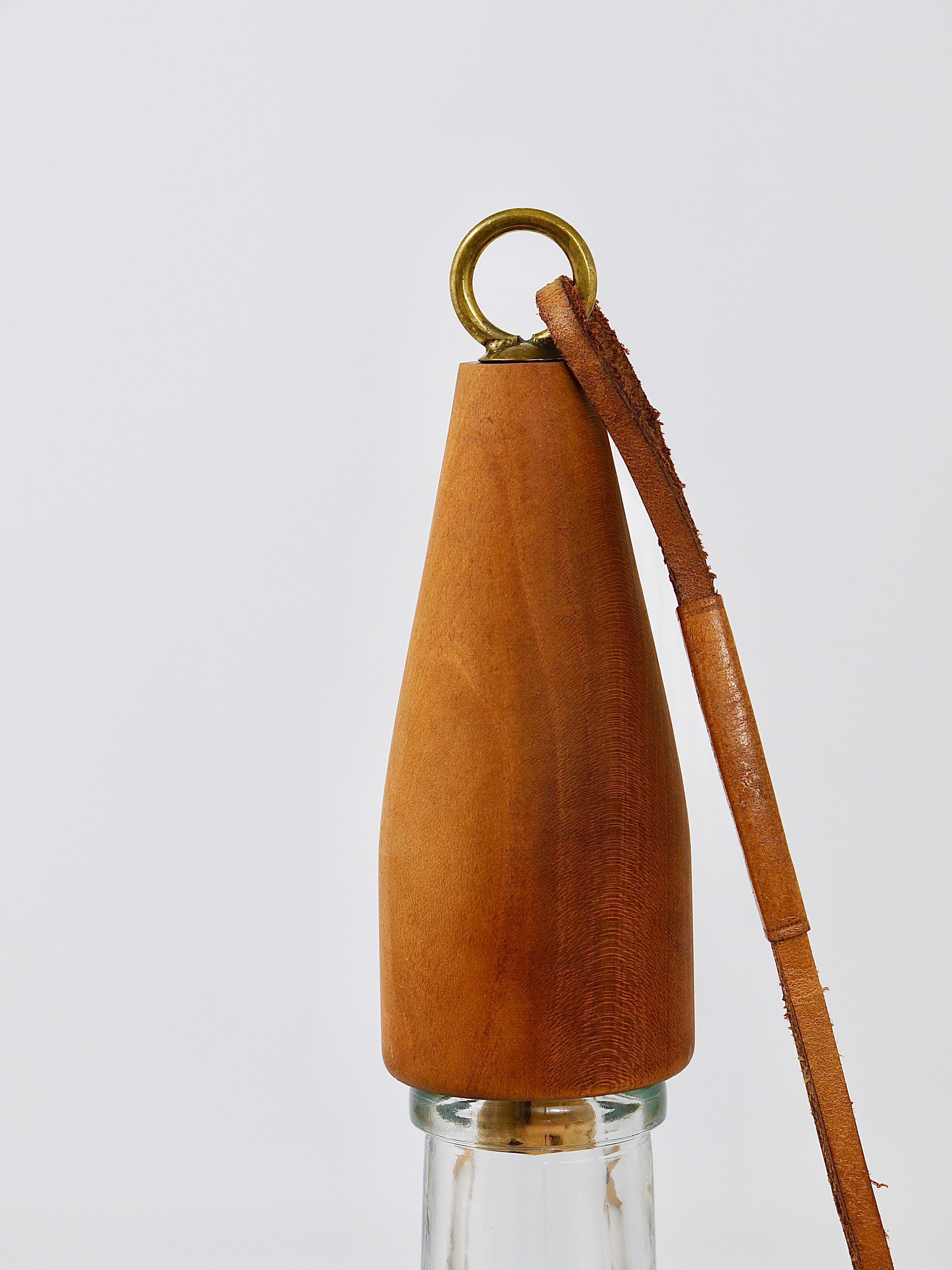 A beautiful Austrian modernist bottle stopper, made of walnut and brass and the original leather string, designed and executed in the 1950s by Carl Auböck, Vienna. In very good condition.