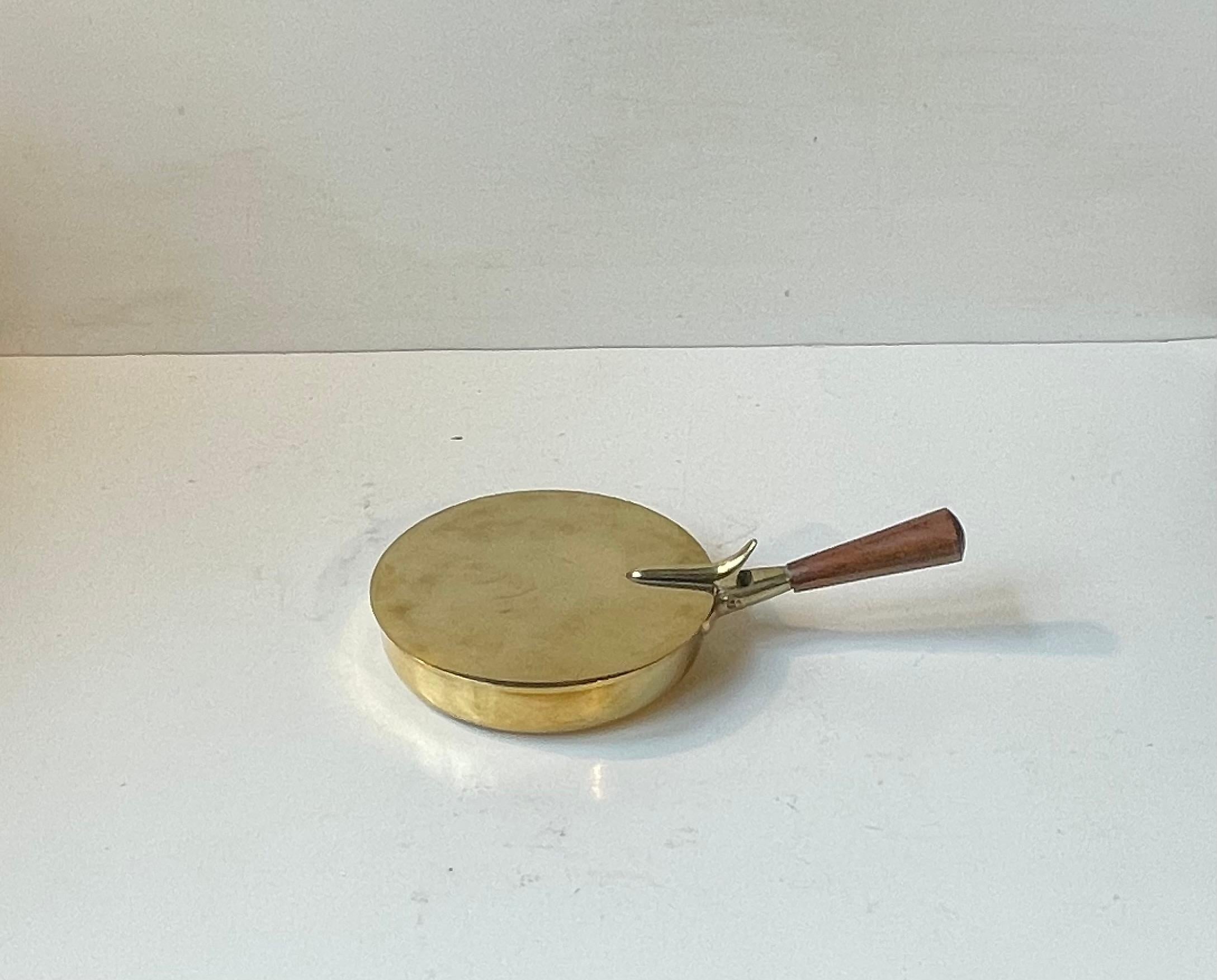 Elegant gearbeiteter Aschenbecher aus Messing mit stilisiertem Walnussholzgriff, entworfen von Carl Aübock und in den 1950er Jahren in Lizenz von Illums Bolighus hergestellt. In den 1950er Jahren war er ein teurer Artikel, und sein Zweck als