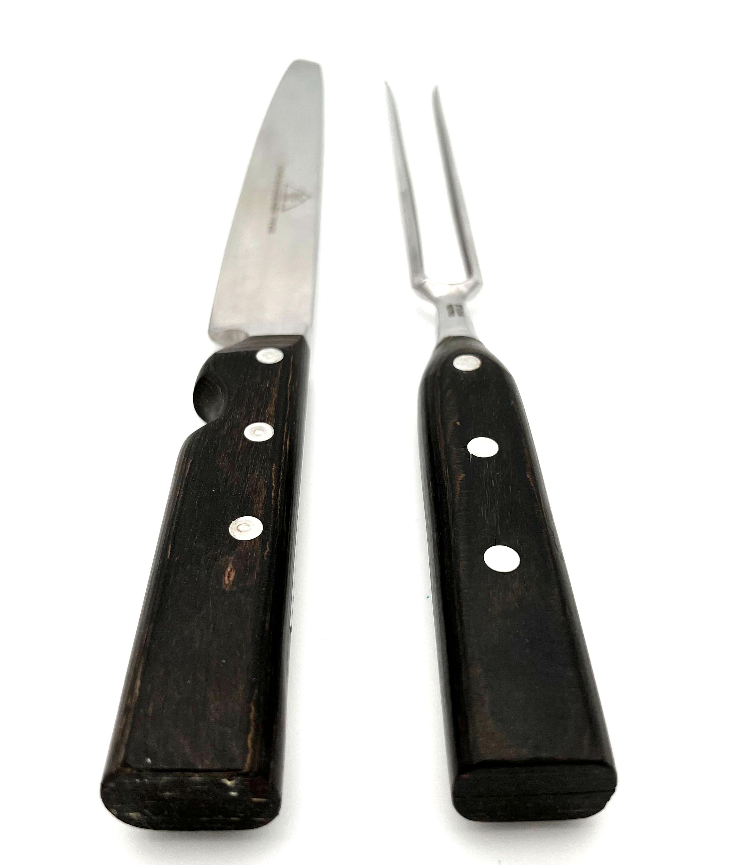 A carving knife and a carving fork from the 1960s, made in Vienna, by Carl Auböck - signed on the knifeblade.
The set is made of hand forged stainless Alpine steel [Alpenstahl]. The handles are made of wood. 

On one side of the knife blade is