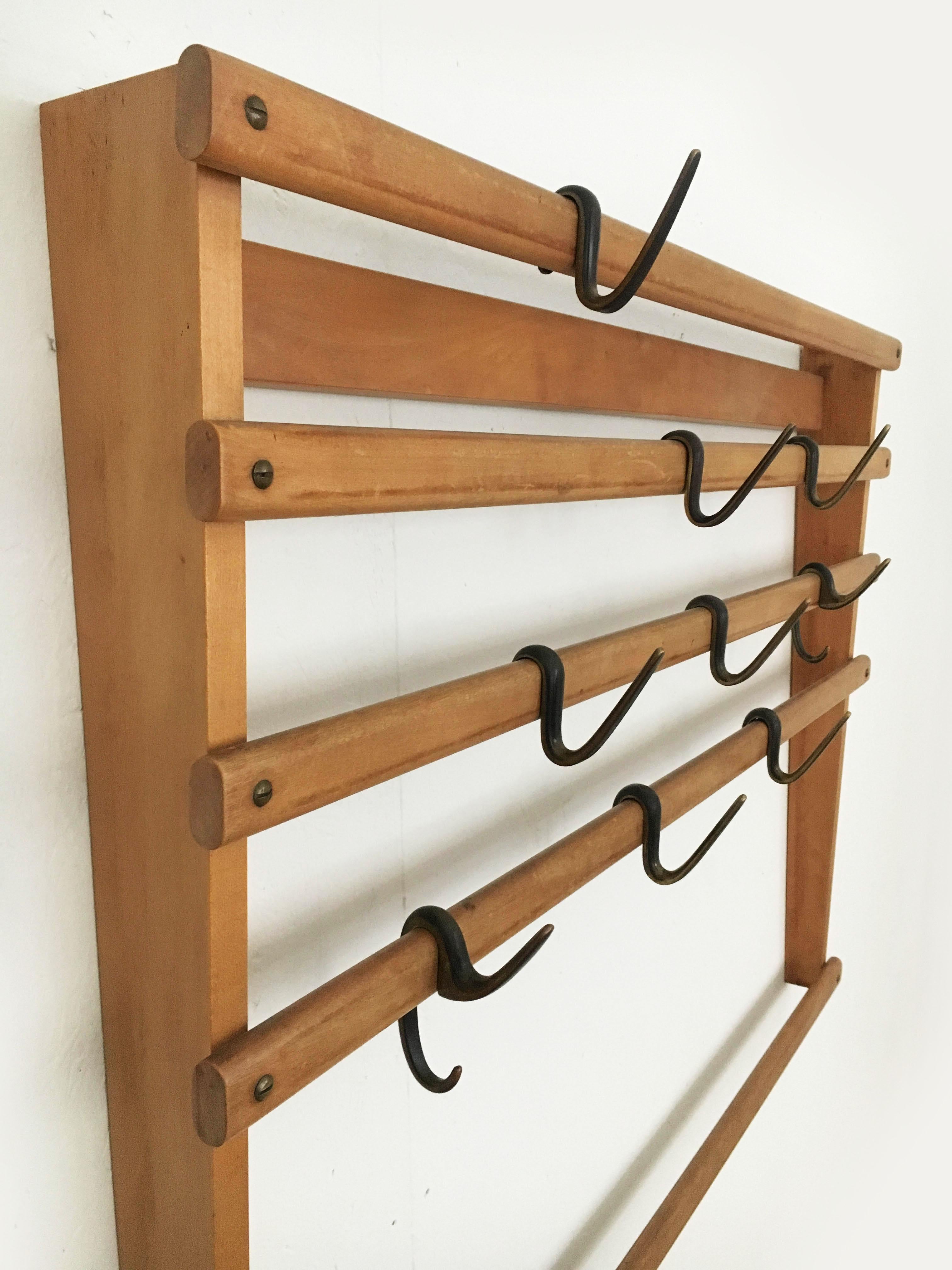 Beautiful rare wall-mounted coat rack wardrobe by Carl Auböck. The two 'G'- and seven 's'-shaped hooks are cast brass and finished combining two surface treatments. They are black patinated and polished on their sides. In excellent vintage condition