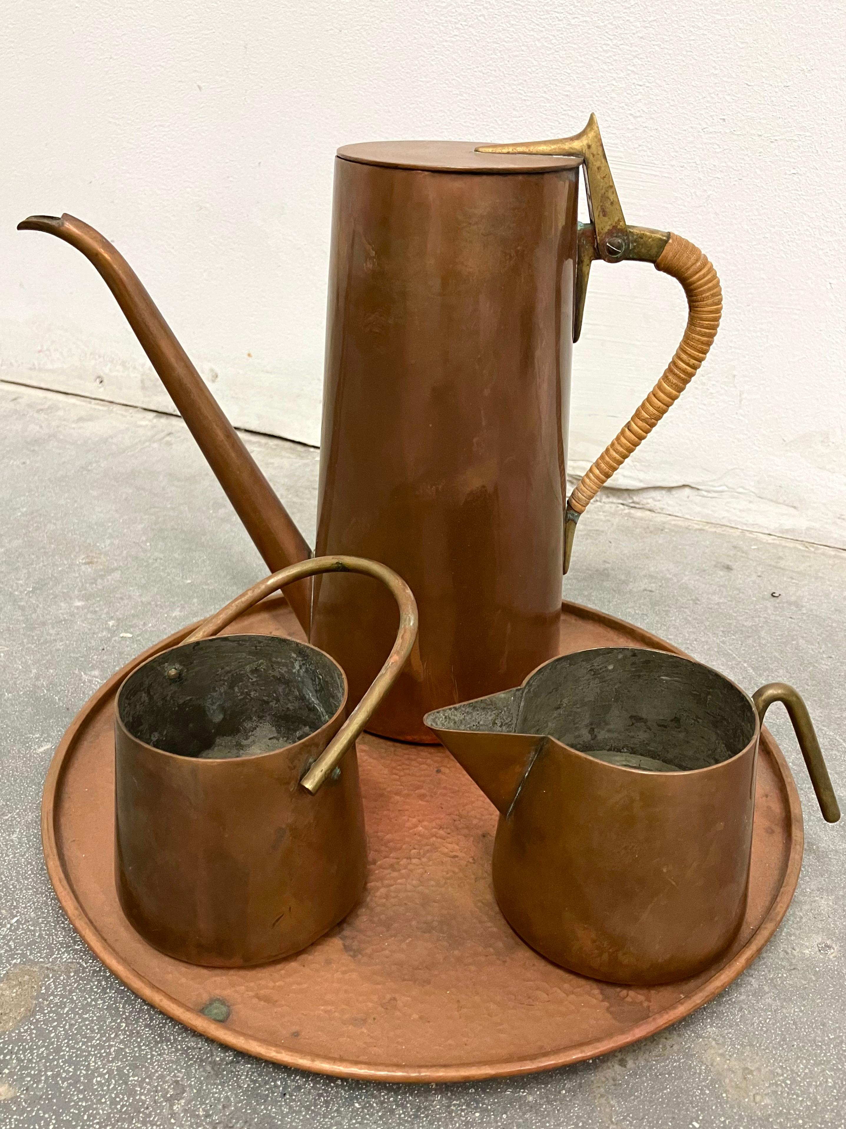 Graceful design in copper, brass and wrapped cane. Includes coffee pot, cream and sugar servers and serving tray. Signed.