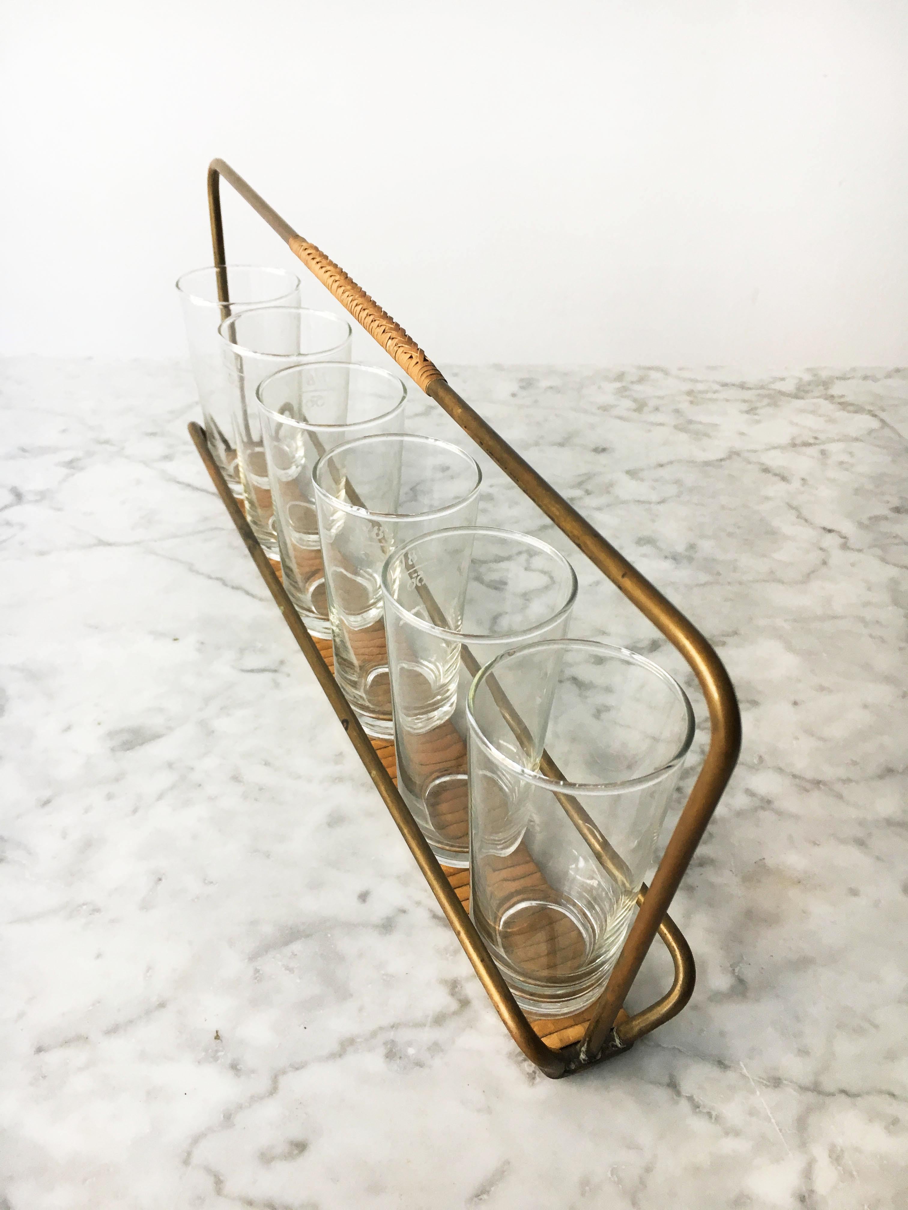 Vintage brass drinks carrier and six drinking glasses by Carl Auböck II, Vienna, circa 1950. The carrier is cast in solid brass wrapped in cane. In excellent condition with just the right amount of lovely gently aged patina.
       