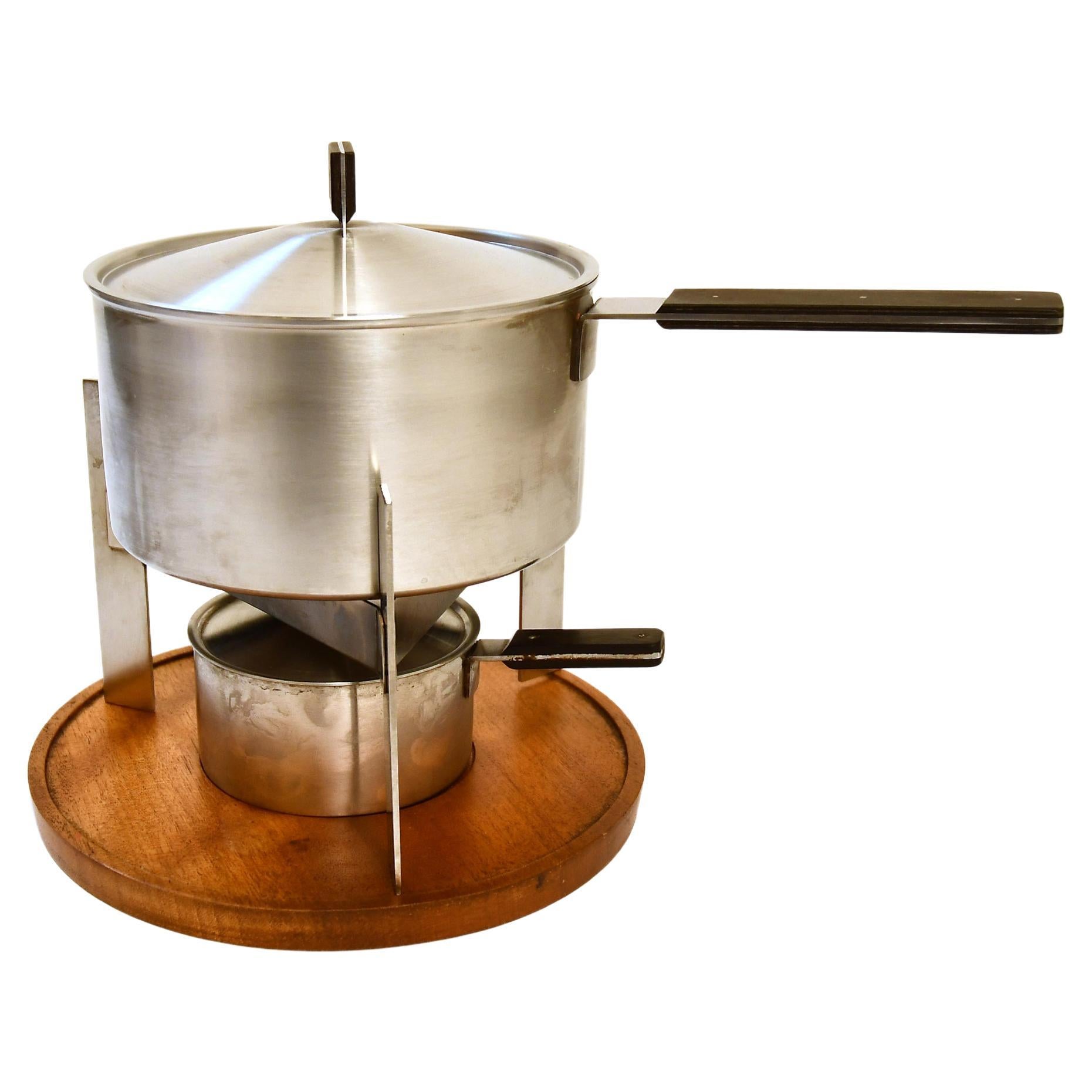 Carl Aubock desigend this Fondue-set in the 1960. Included is the original box made of paper. The contents of the packaging are described on the lid in 4 languages: 
Fondue-Set in six parts: fondue-pot, stainless, 2 pints :: cover for the