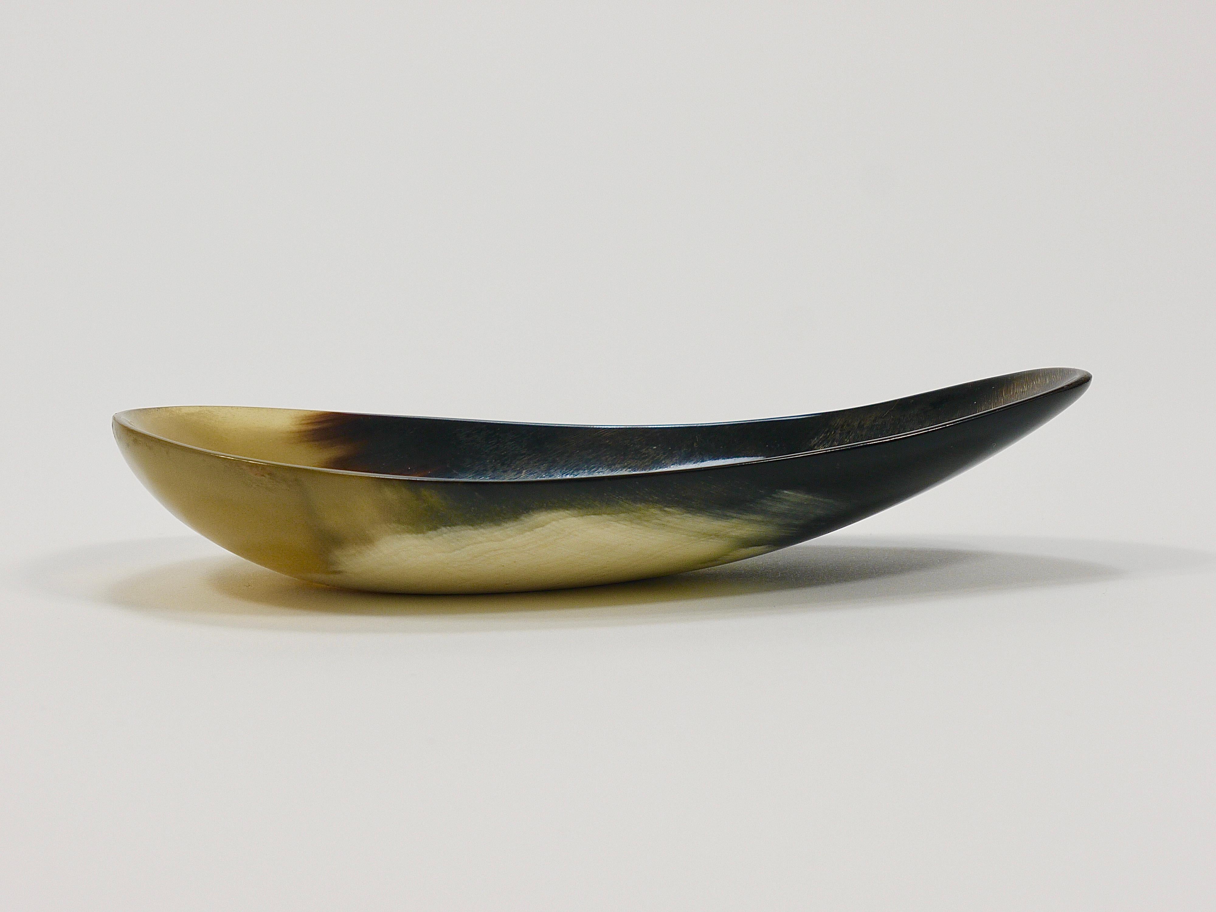 A beautiful and minimalistic mid-century modern bowl from the 1950s, shaped like a drop, made of cow horn. Designed and manufactured by Werkstätte Carl Auböck, Vienna, Austria. A very decorative piece that is versatile, for example, on a set table