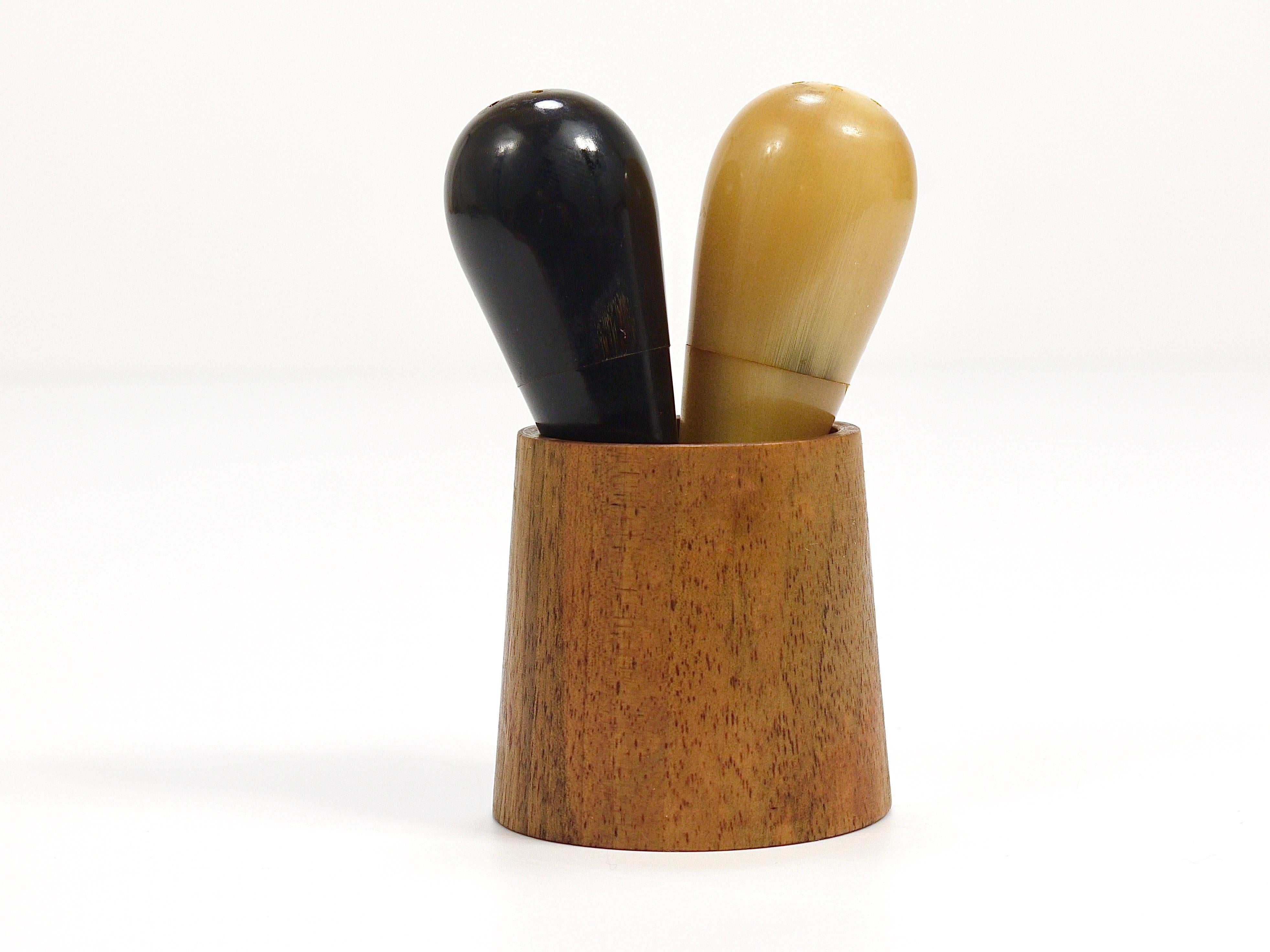 A wonderful and rare pair of Midcentury modern minimalism salt and pepper shakers from the 1950s. Designed and manufactured by Werkstatte Carl Aubock Vienna. The drop shaped shakers are made of light and dark ox cow horn, its wooden cup holder is