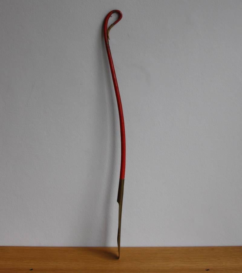 A vintage leather and brass shoe horn designed and made by Carl Auböck II, Vienna, circa 1950.
The leather is colored in scarlet red and is in overall good condition, with minor losses and wear consistent with age and use. The brass has a uniform