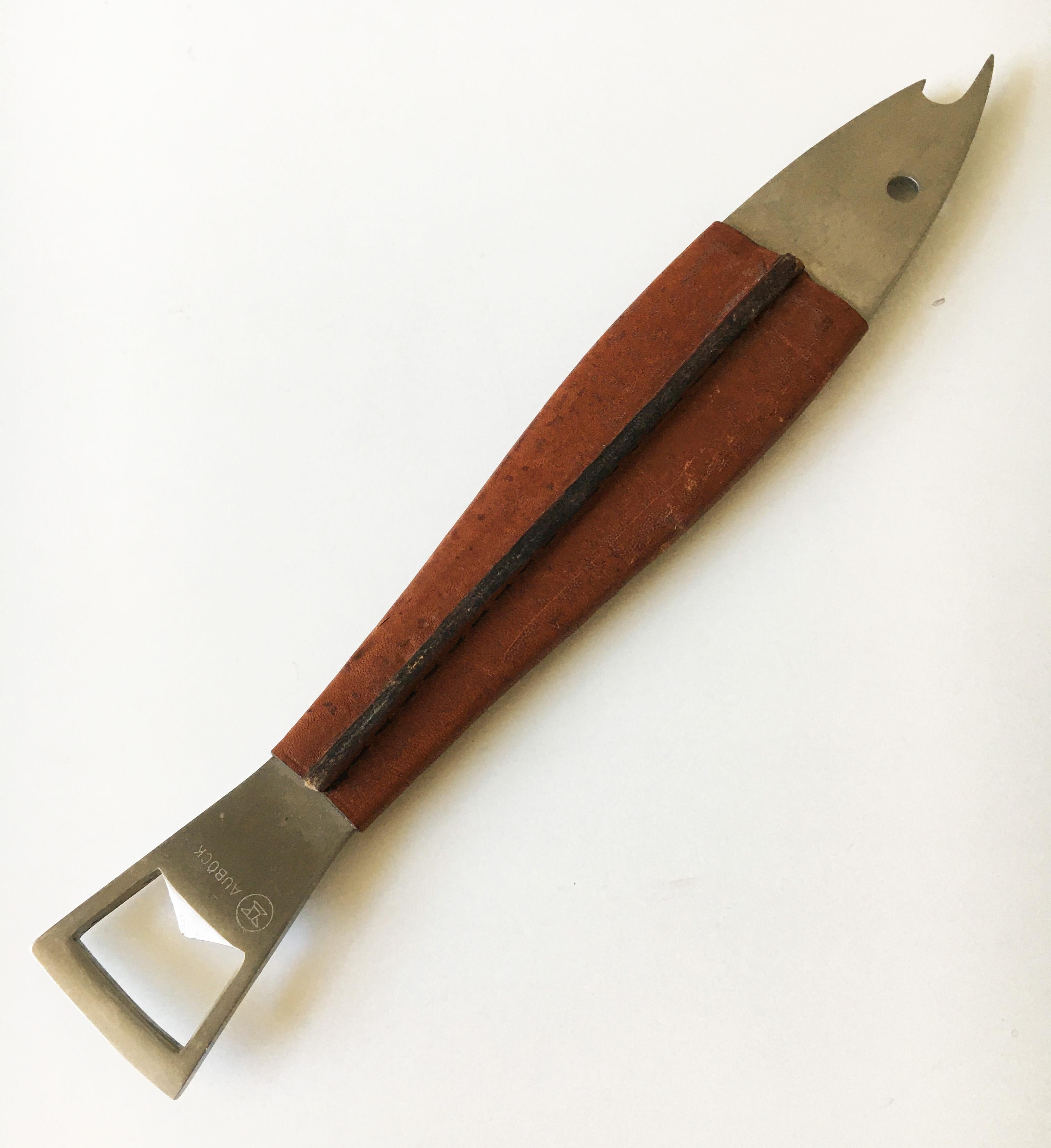 A beautiful fish-shaped modernist bottle opener from the 1950s Neptune #1, made of stainless steel, covered with cognac leather. Designed by Carl Auböck. Executed by Amboss Austria. Lovely, soft warm patina to the leather. Marked: AUBÖCK & STAINLESS