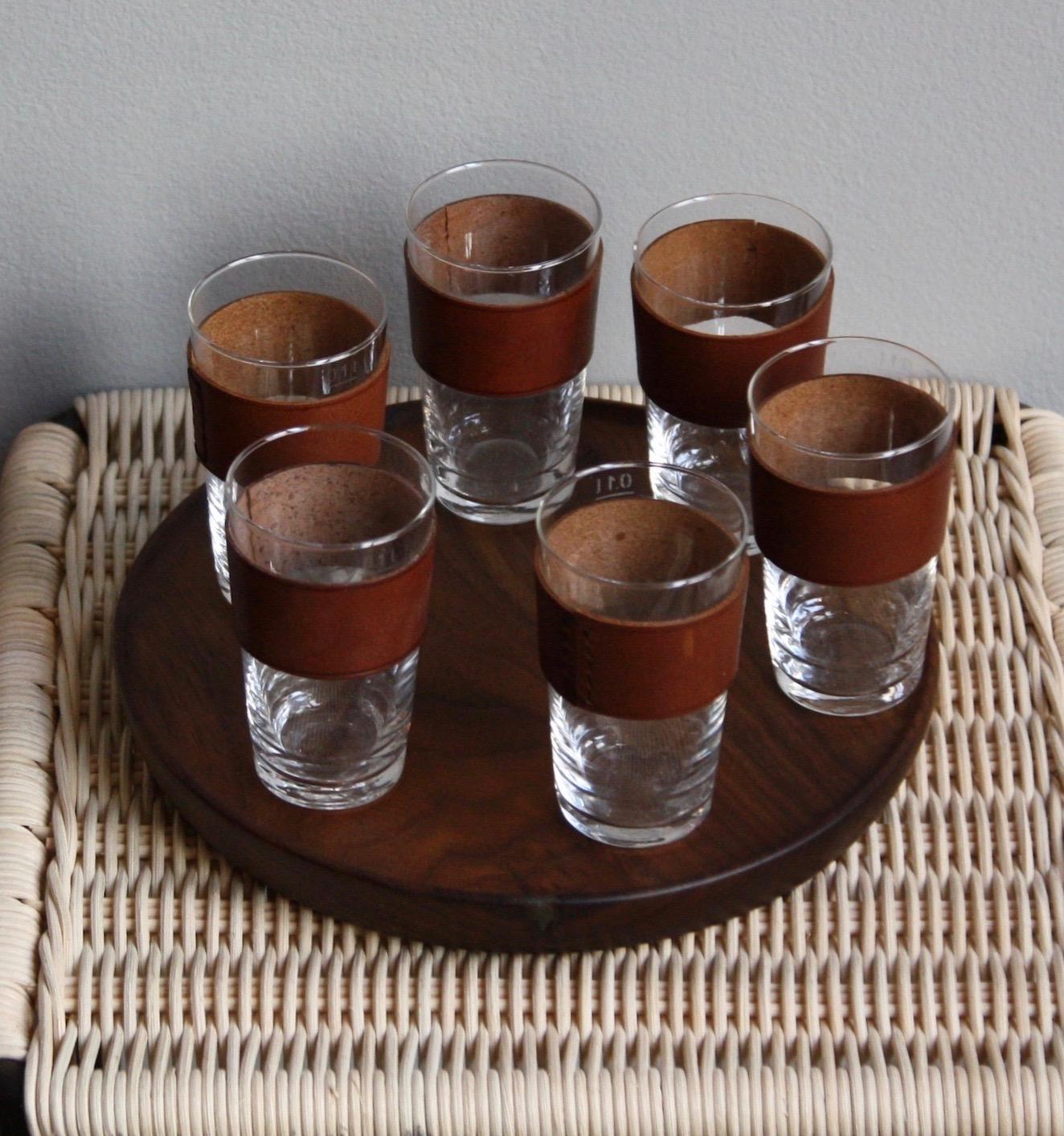 A vintage, completely original, schnapps set designed and made by Carl Auböck II, Vienna, circa 1950. The set consists of a walnut board and six glasses. Each glass is made of hand blown glass with a very high lead content which gives the glass