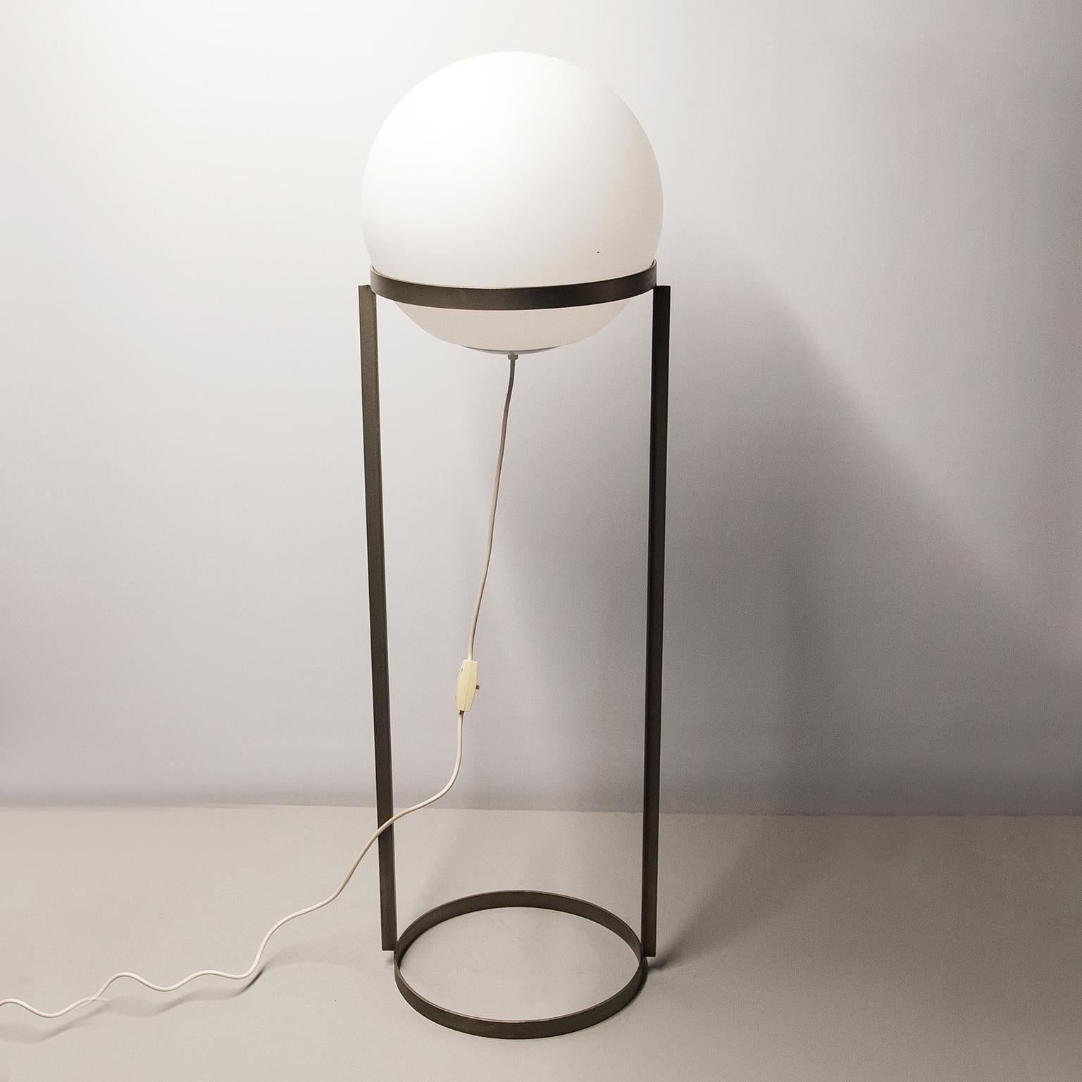 Carl Auebock a conçu et fabriqué ce rare lampadaire en 1969.
Le nom du modèle est 4095 et il s'appelle Kugelleuchte, comme lampe à boule.
Elle est composée d'un cadre en métal nickelé et d'un abat-jour en verre dépoli qui donne une très belle