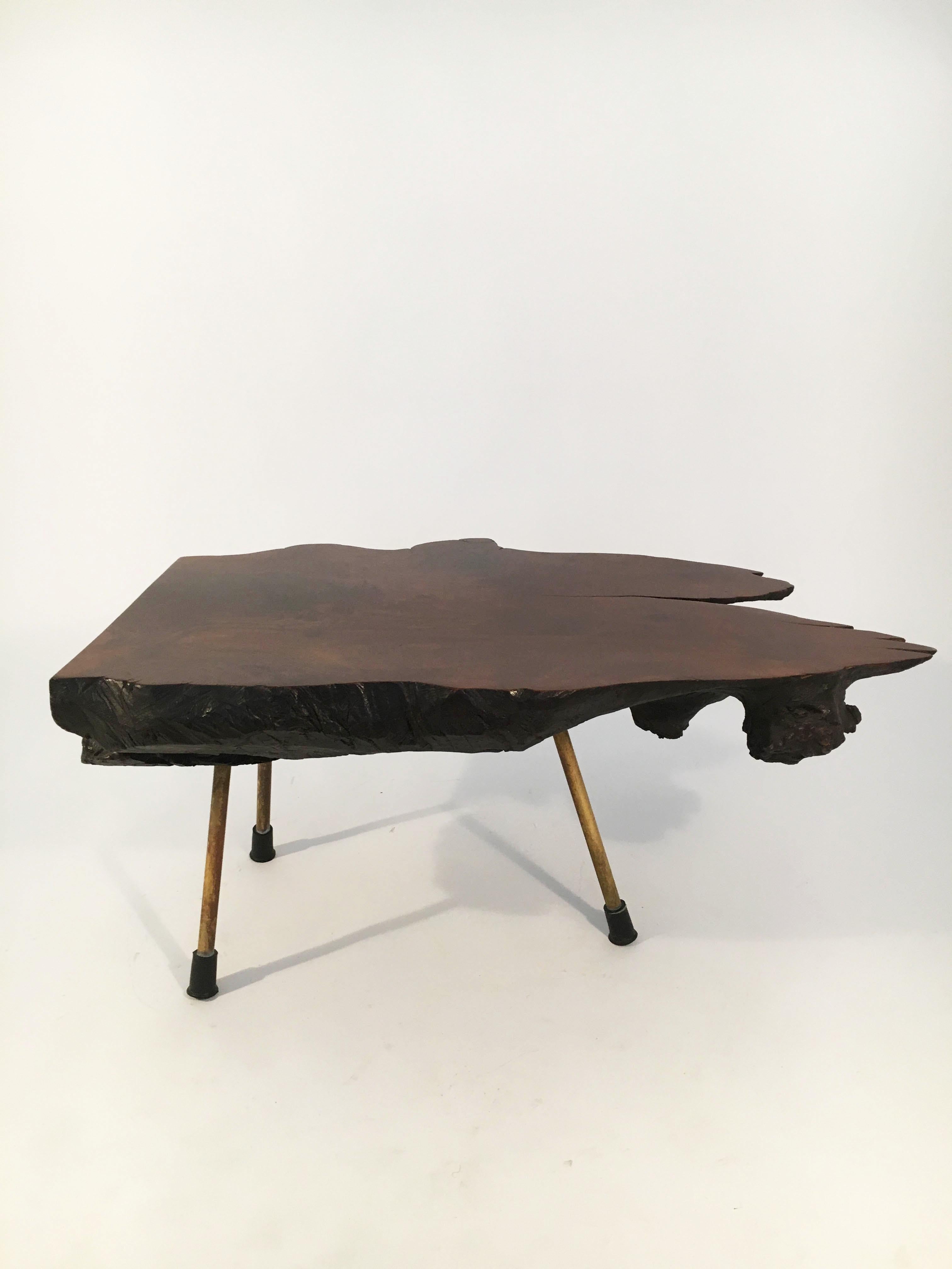 Dramatic large tree trunk table with a great color and size. One of the finest we have ever seen. Marked on the leg with the numbers 1, 2, 3. In excellent vintage condition with just the right amount of gently aged patina on the brass legs and