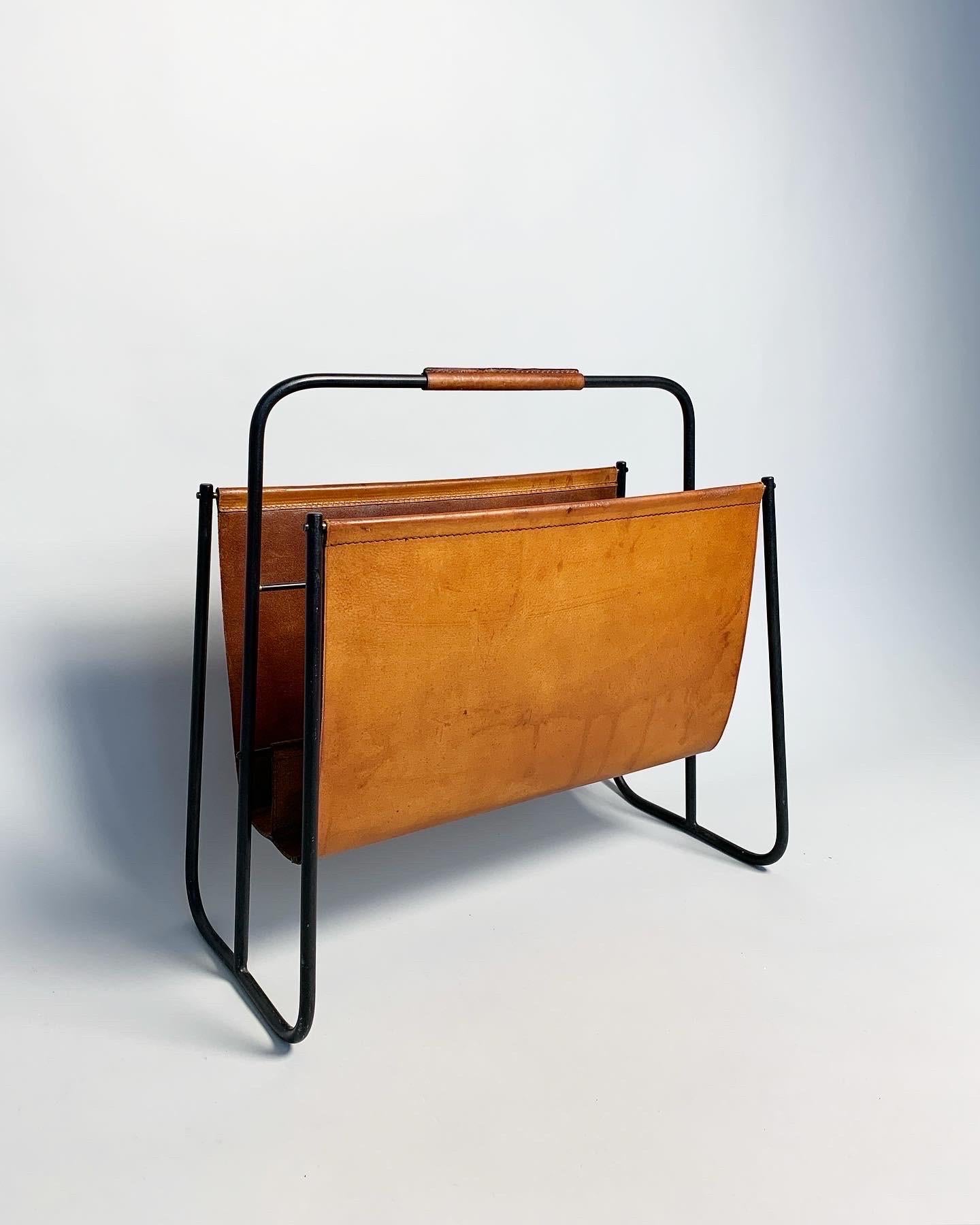 Rarely seen Carl Auböck magazine rack with a black frame, hand crafted by the Auböck workshop in Vienna, Austria in the 1950s.

Solid, hand shaped in blackened steel, stitched leather with a strong patina.

Measures: Width: 46 cm
Depth: 25