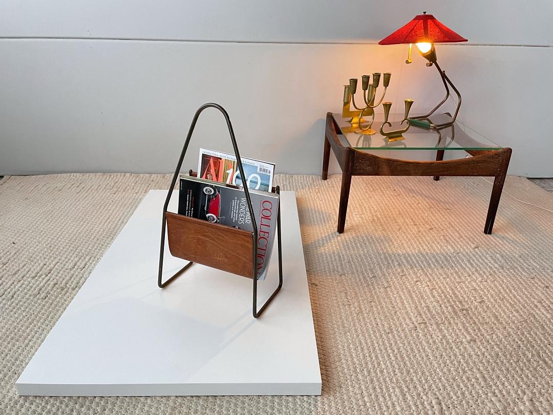 Timeless Mid-Century Modern newspaper/magazine stand no. 3808 designed by Carl Auböck II from early 1950s, signed and manufactured by Auböck Werkstätte in Vienna. It's made of solid brass and leather. The magazine rack is in very good condition,