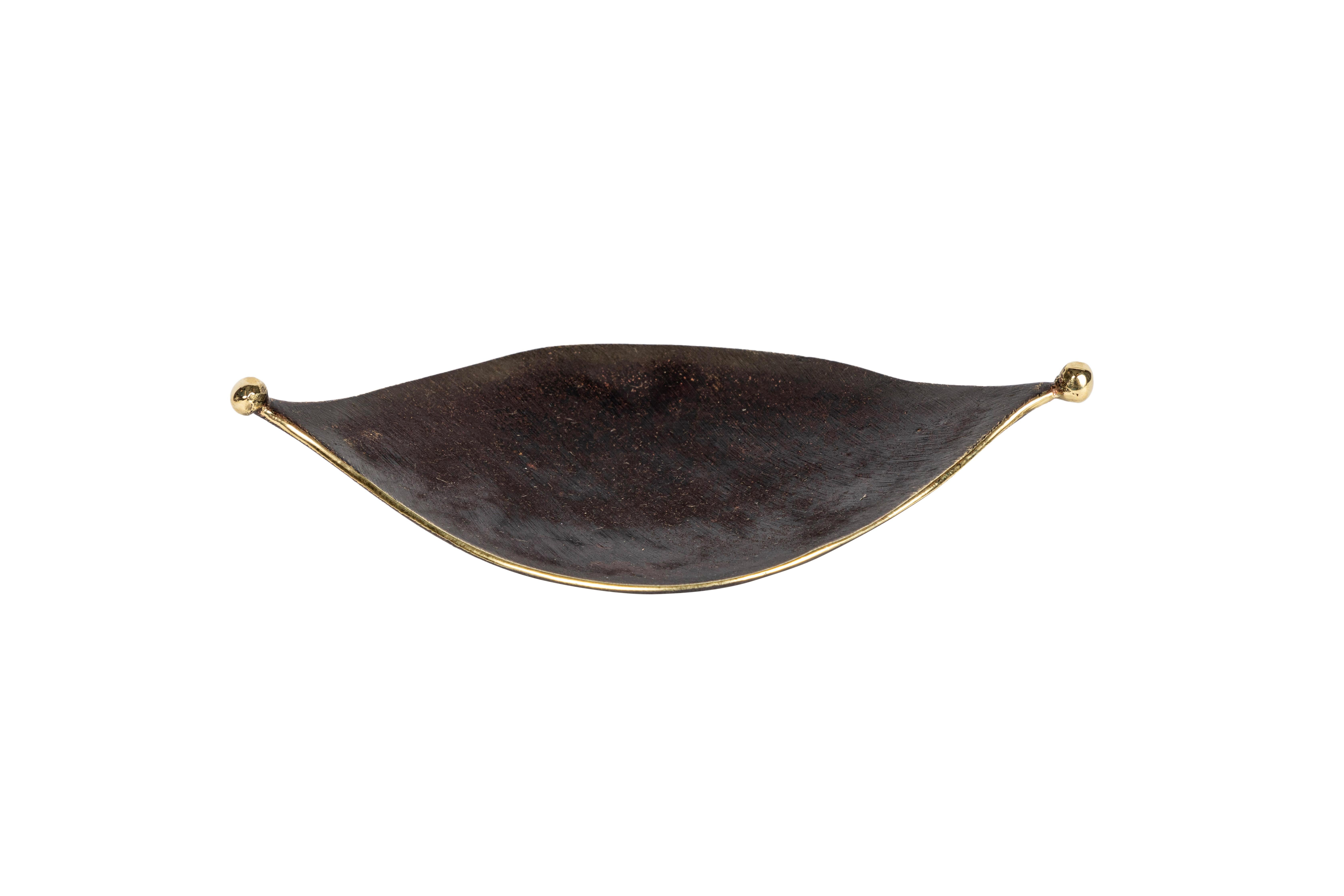 Carl Auböck model #3431 'Knopferl' brass tray. Designed in the 1950s, this incredibly refined and sculptural Viennese tray is executed in patinated and polished brass. This petite decorative tray can be used for a variety of purposes.

Price is per