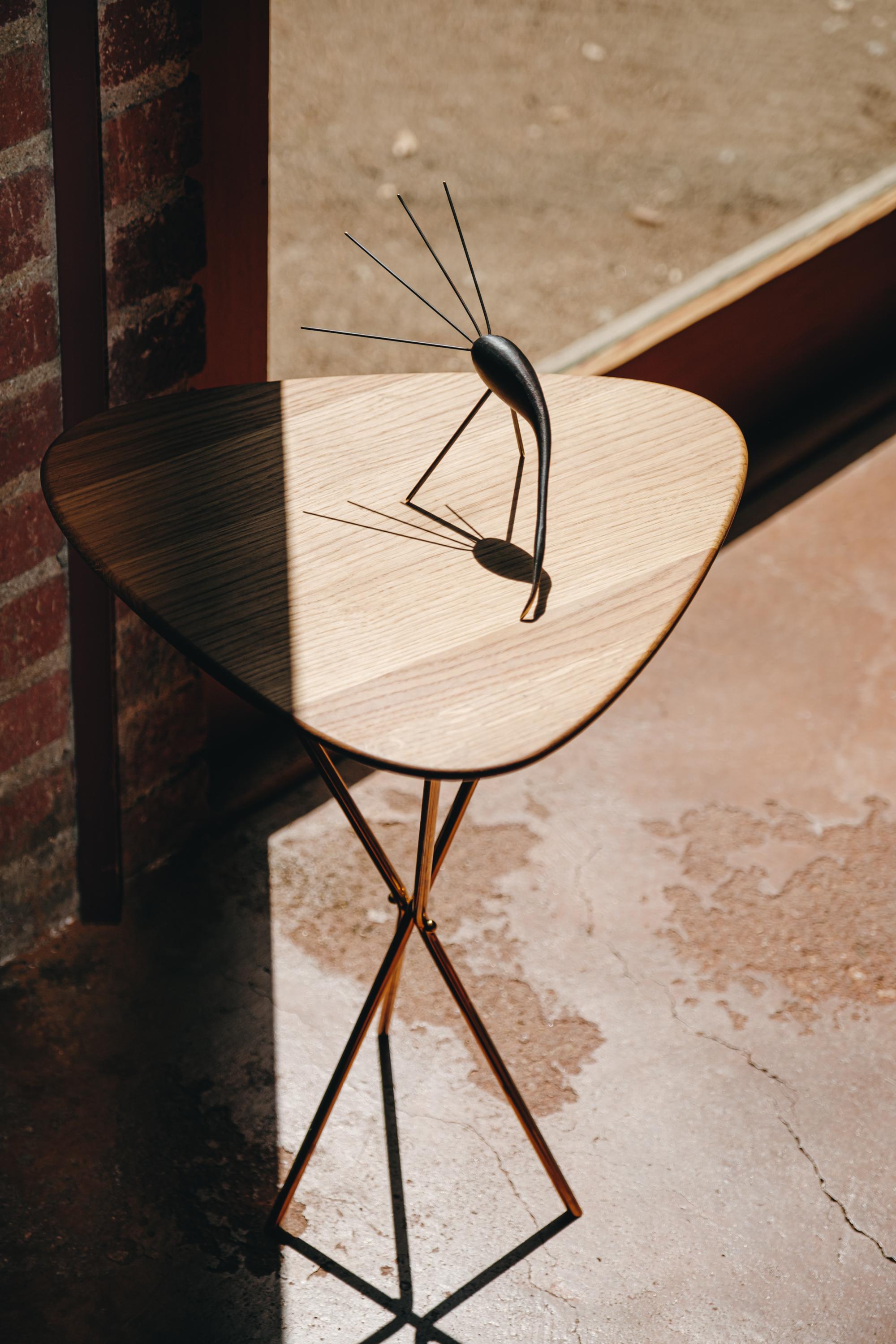 Carl Aubo¨ck model #3642 brass and oak table designed in the 1950s, this incredibly refined and sculptural table is executed in beautifully grained oak and polished brass. Inspired by the folding map tables carried by French officers under Napolean,