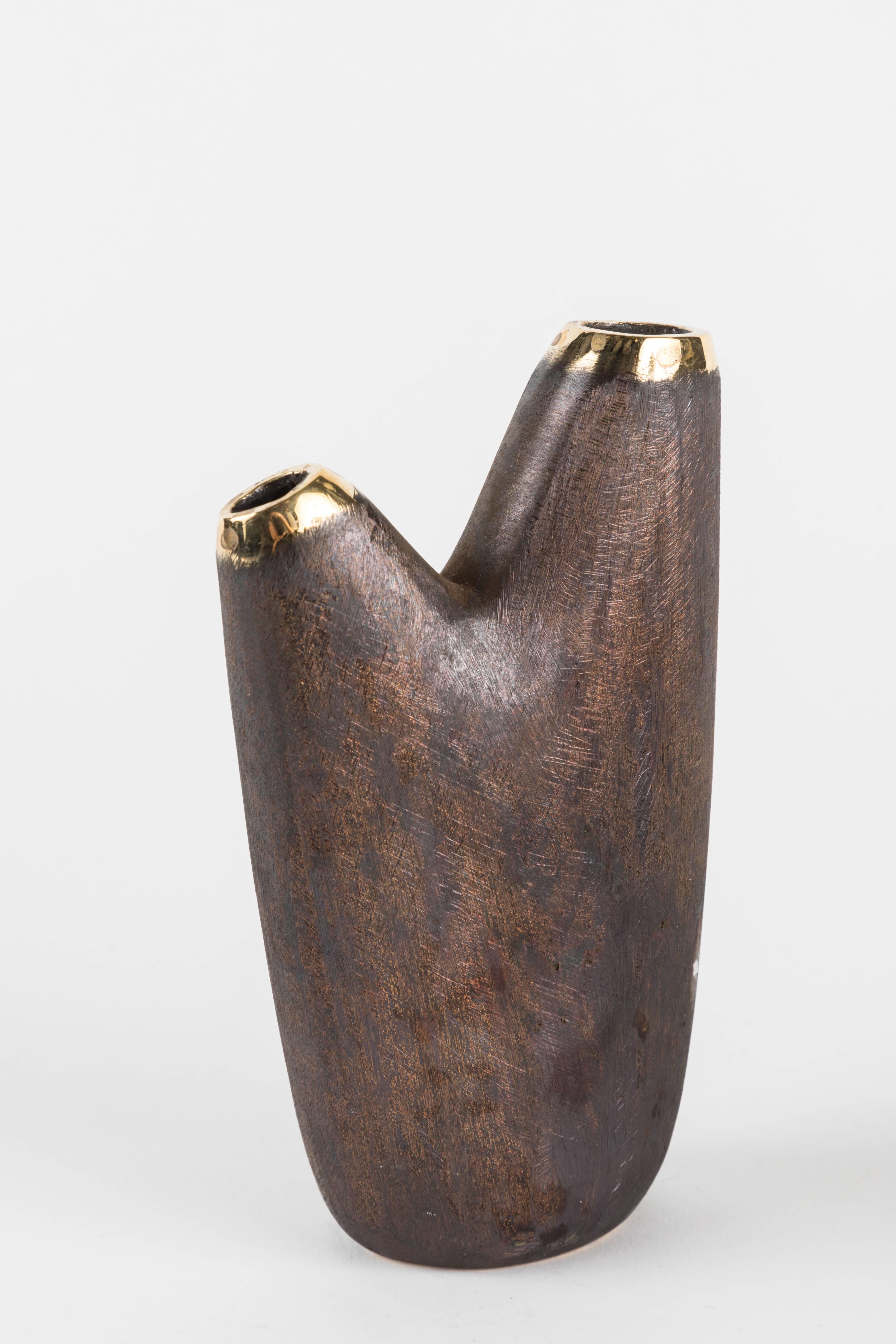 Carl Aubo¨ck Model #3794 'Aorta' brass vase. Designed in the 1950s, this incredibly refined and sculptural Viennese vase is executed in polished and darkly patinated brass by Werkstätte Carl Auböck, Austria. 

Price is per item. Other Aubock vase