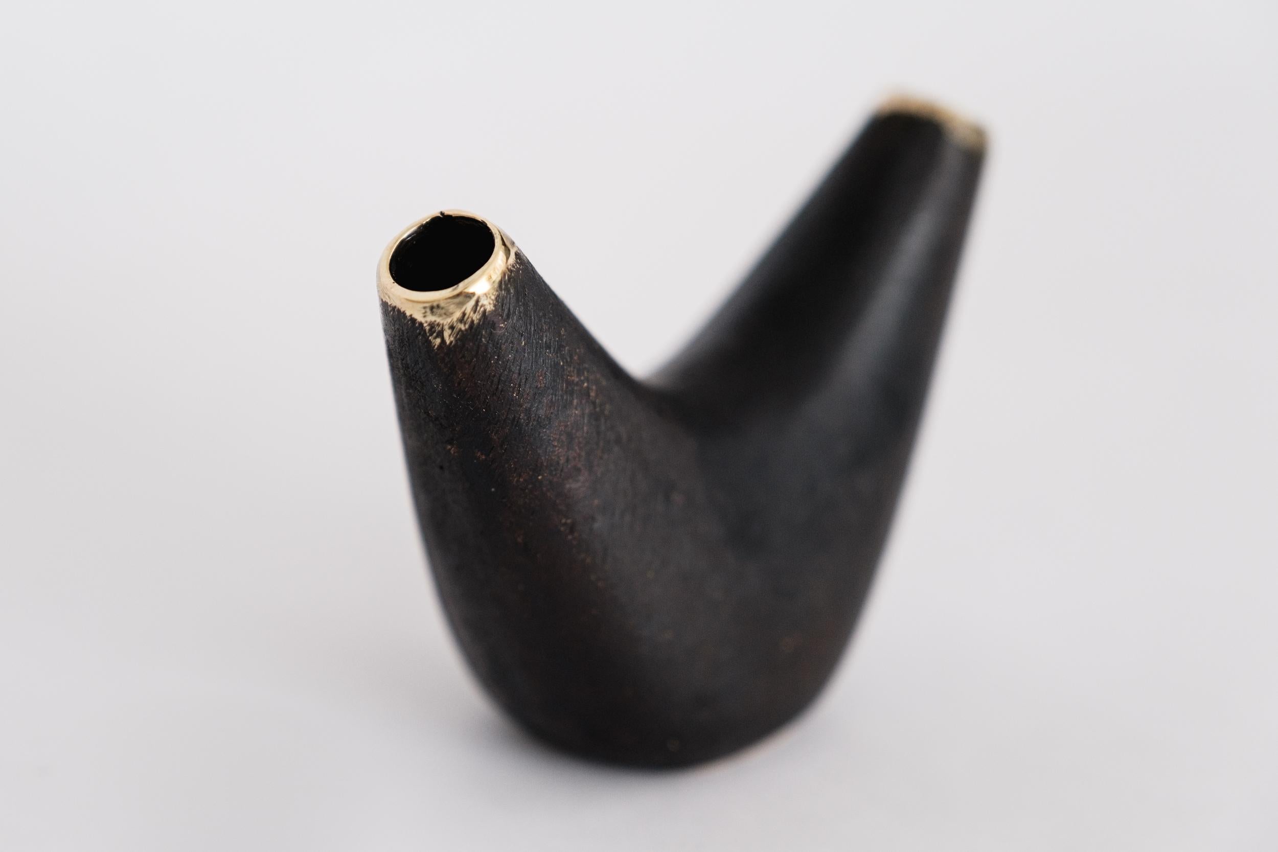 Carl Aubo¨ck Model #3795 'Aorta Crescent' brass vase. Designed in the 1950s, this incredibly refined and sculptural Viennese vase is executed in polished and darkly patinated brass by Werkstätte Carl Auböck, Austria. 

Produced by Carl Auböck IV in