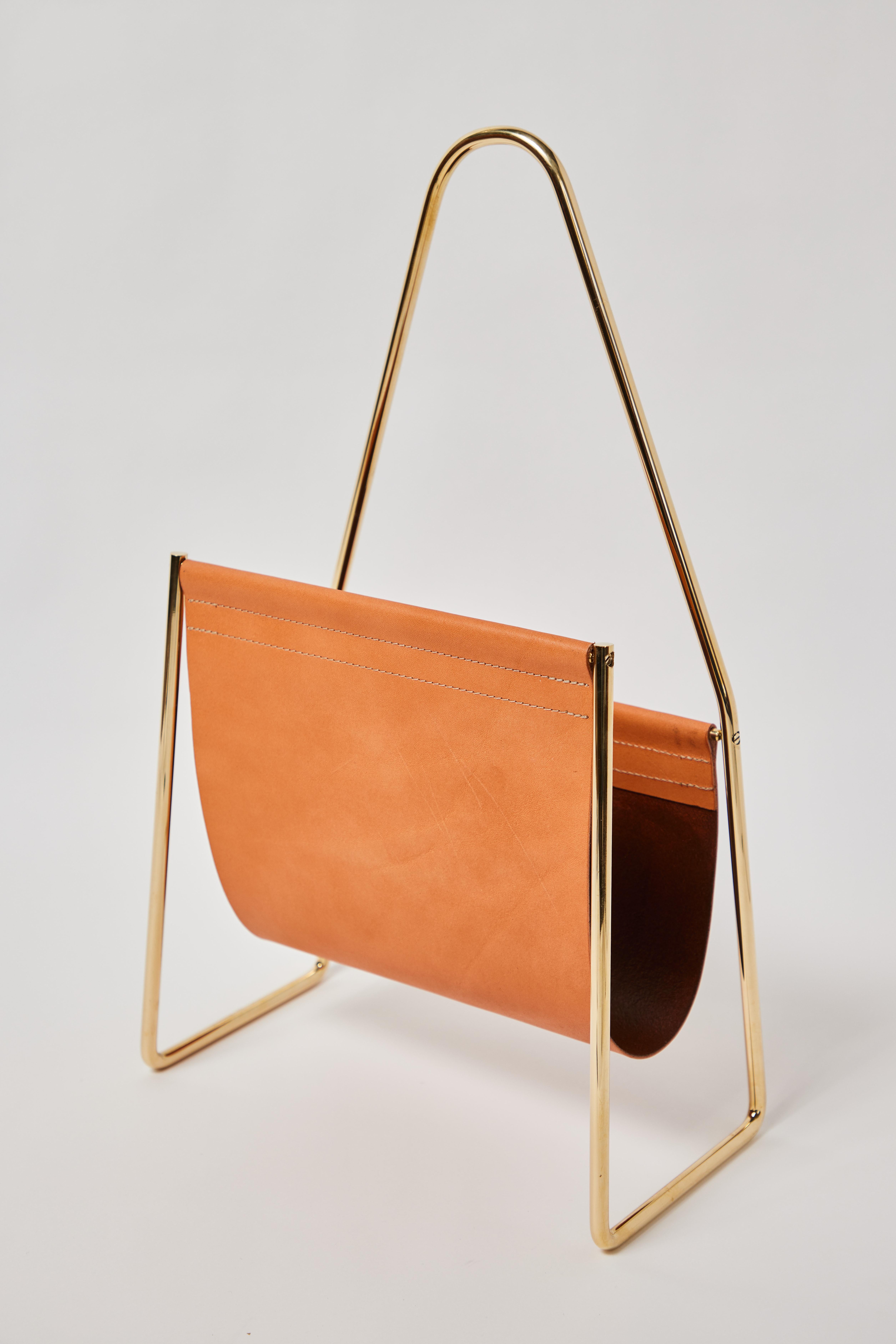 Carl Auböck model #3642 brown leather and brass table designed in the 1950s, this incredibly refined and sculptural magazine rack is executed in beautifully grained brown cowhide leather and polished brass.

Price is per item. 1 in stock. Out of