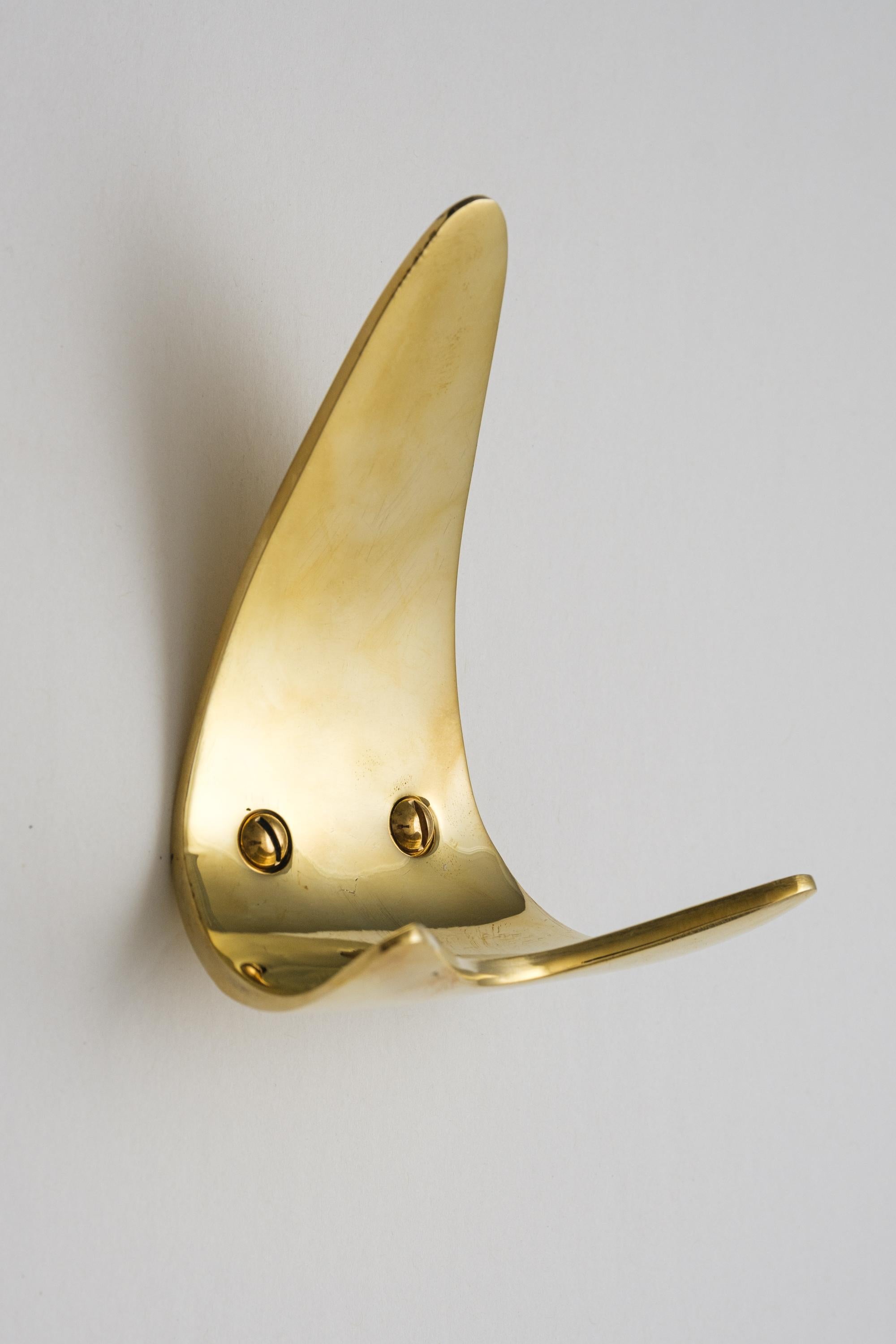 Carl Auböck Model #4086 hook in polished brass. Designed in the 1950s, this versatile and Minimalist Viennese hook is expertly executed in polished brass by Werkstätte Carl Auböck, Austria. 

Produced by Carl Auböck IV in the original Auböck