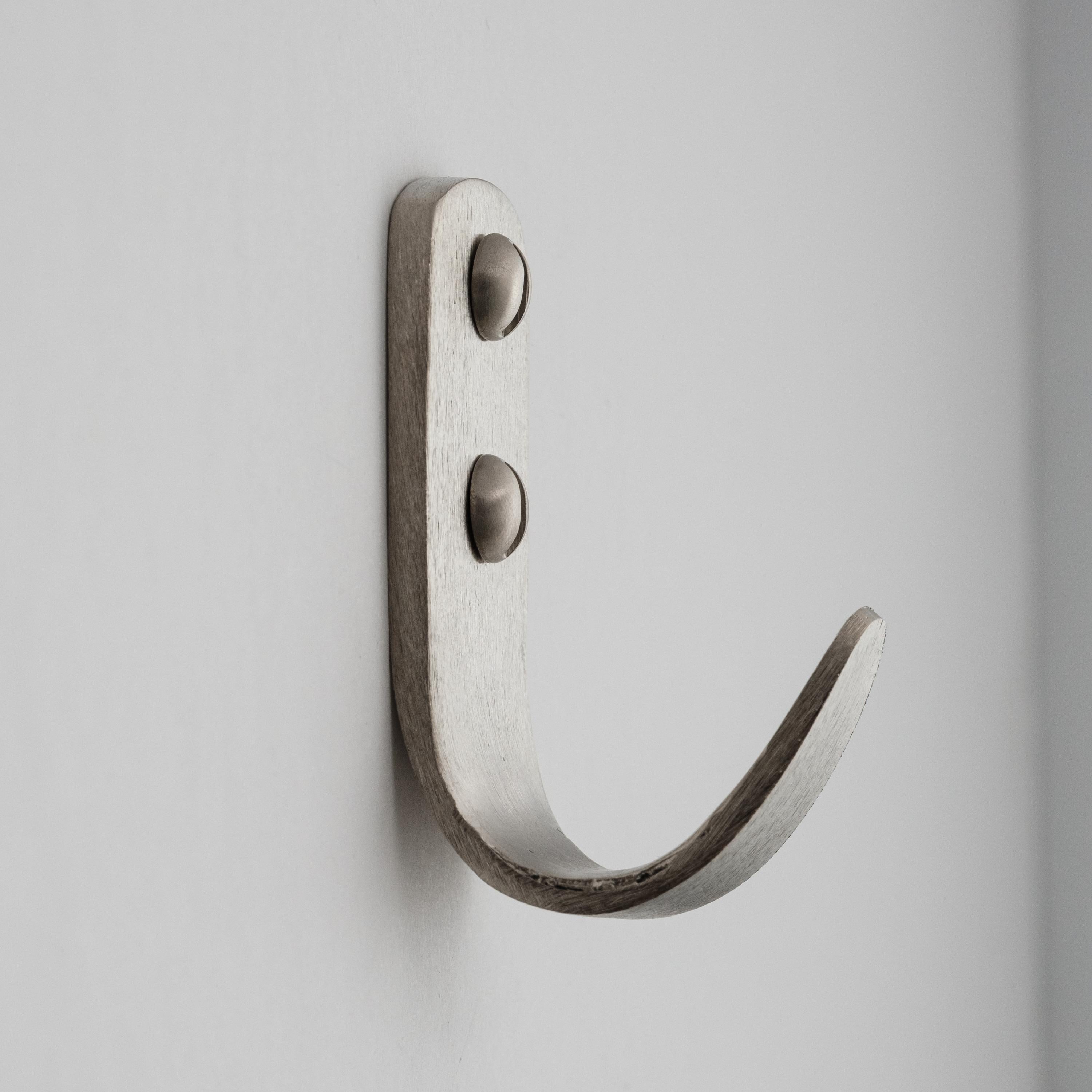 Carl Auböck model #4330/1 hook in nickel. Designed in the 1950s, this versatile and Minimalist Viennese hook is executed in softly brushed nickel by Werkstätte Carl Auböck, Austria. 

Produced by Carl Auböck IV in the original Auböck workshop in the