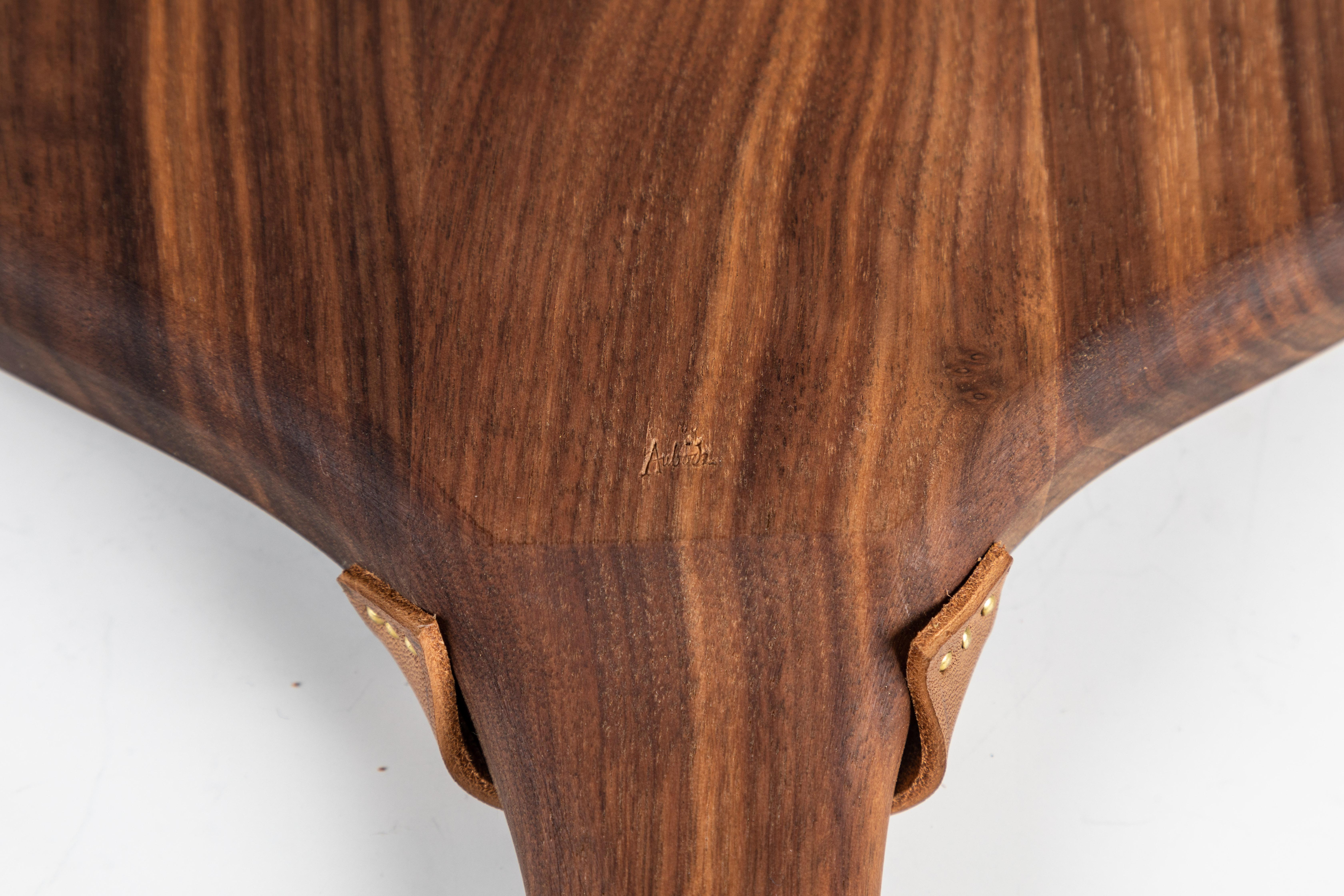 Carl Auböck model #4363 walnut board. Designed in the 1950s, this incredibly refined and sculptural serving or cutting board is executed in beautifully grained walnut and leather.

Price is per item. This listing is for the walnut board only.