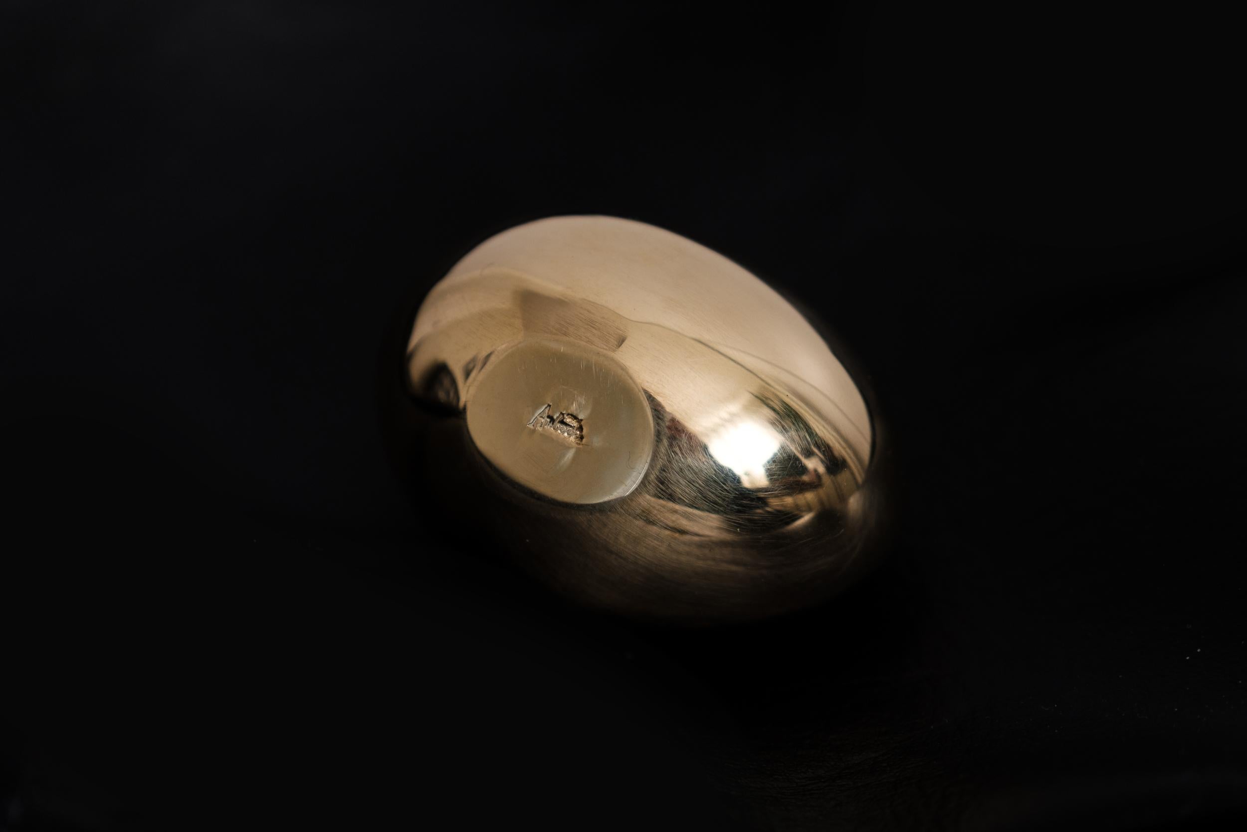 Carl Aubo¨ck Model #4867 'Egg' brass paperweight. Designed in the 1950s, this incredibly clean and refined Viennese paperweight is hand fabricated in polished brass by Werkstätte Carl Auböck, Austria. 

Produced by Carl Auböck IV in the original