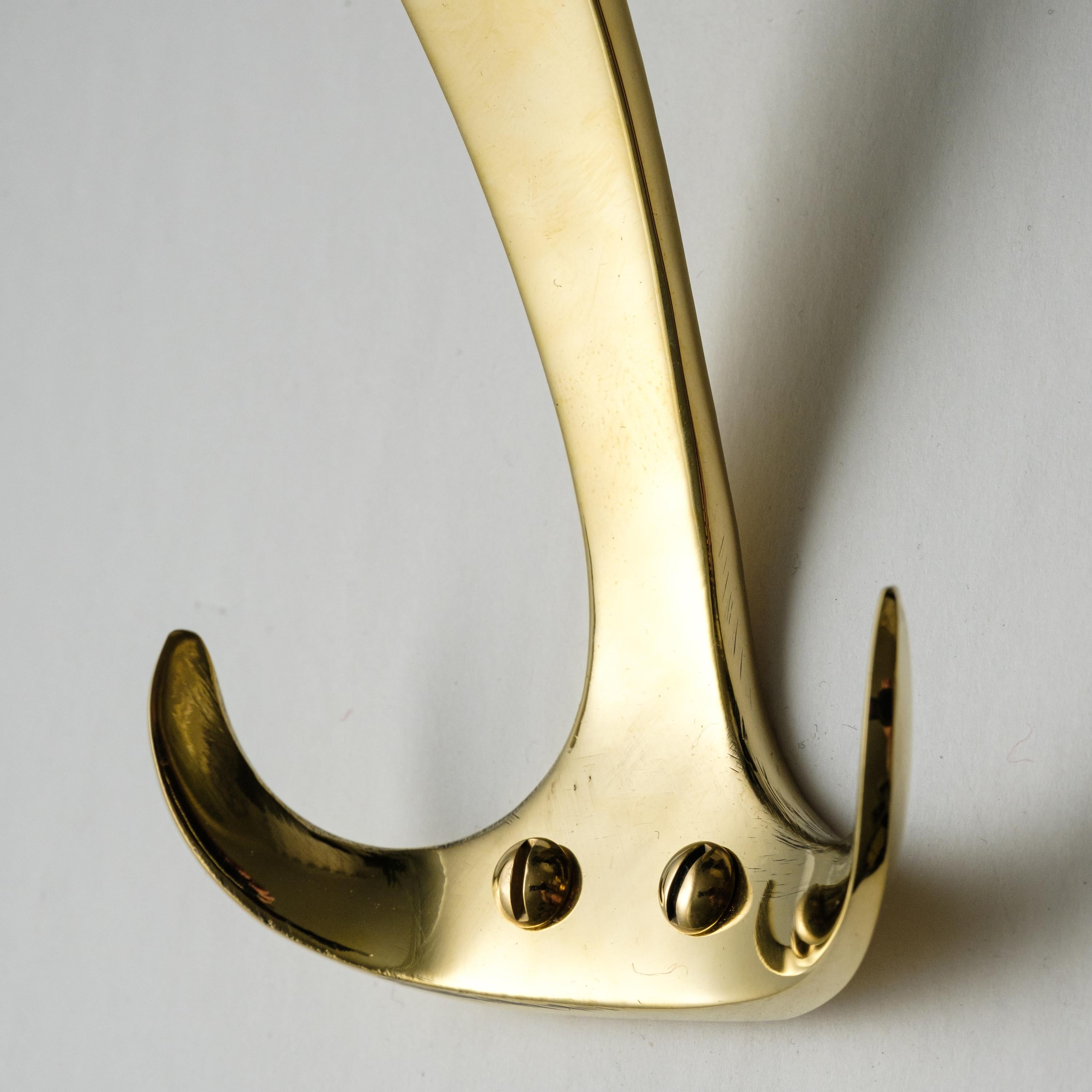 Carl Auböck model #4982 polished brass hook. Designed in the 1950s, this versatile and minimalist Viennese hook is executed in polished brass by Werkstätte Carl Auböck, Austria. 

Produced by Carl Auböck IV in the original Auböck workshop in the 7th