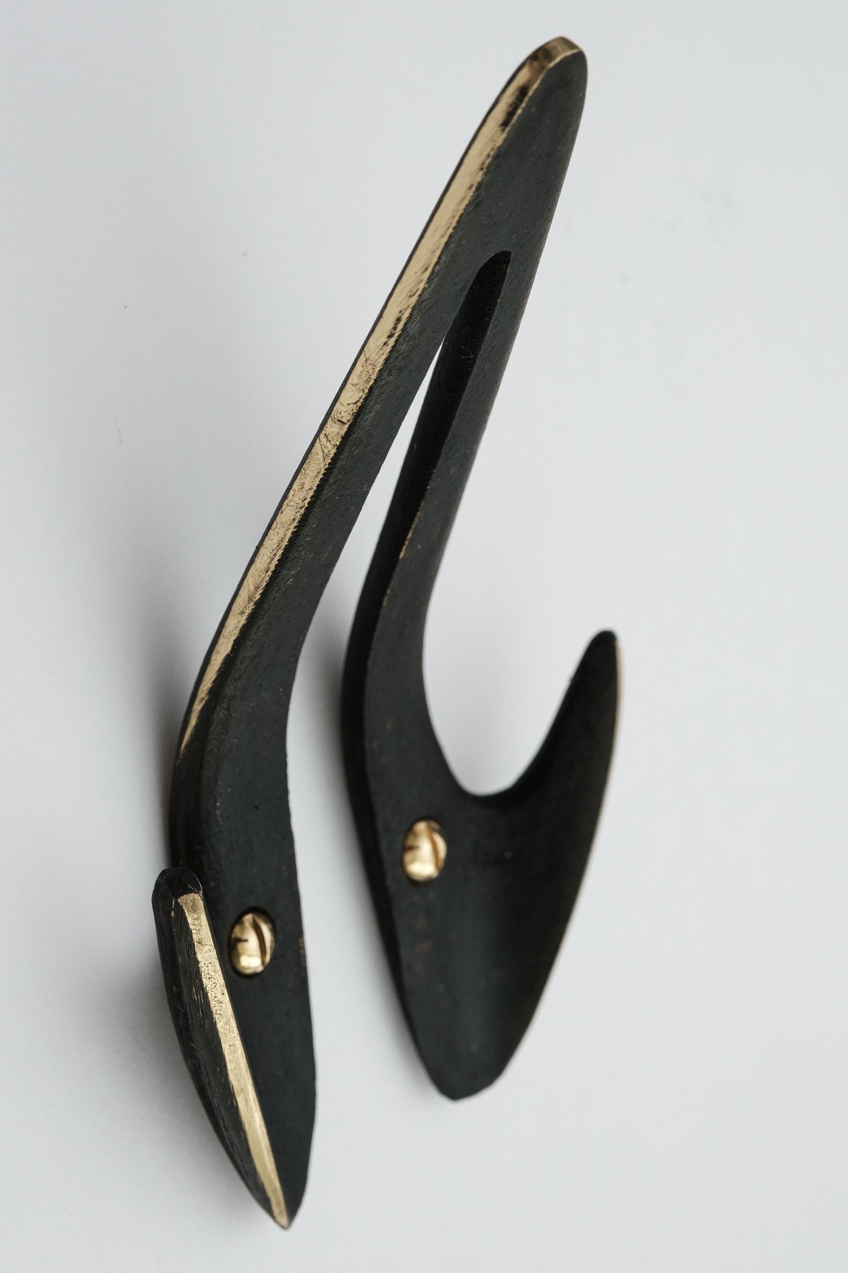 Carl Auböck Model #4994 patinated brass hook. Designed in the 1950s, this versatile and Minimalist Viennese hook is executed in patinated brass by Werkstätte Carl Auböck, Austria. 

Produced by Carl Auböck IV in the original Auböck workshop in the