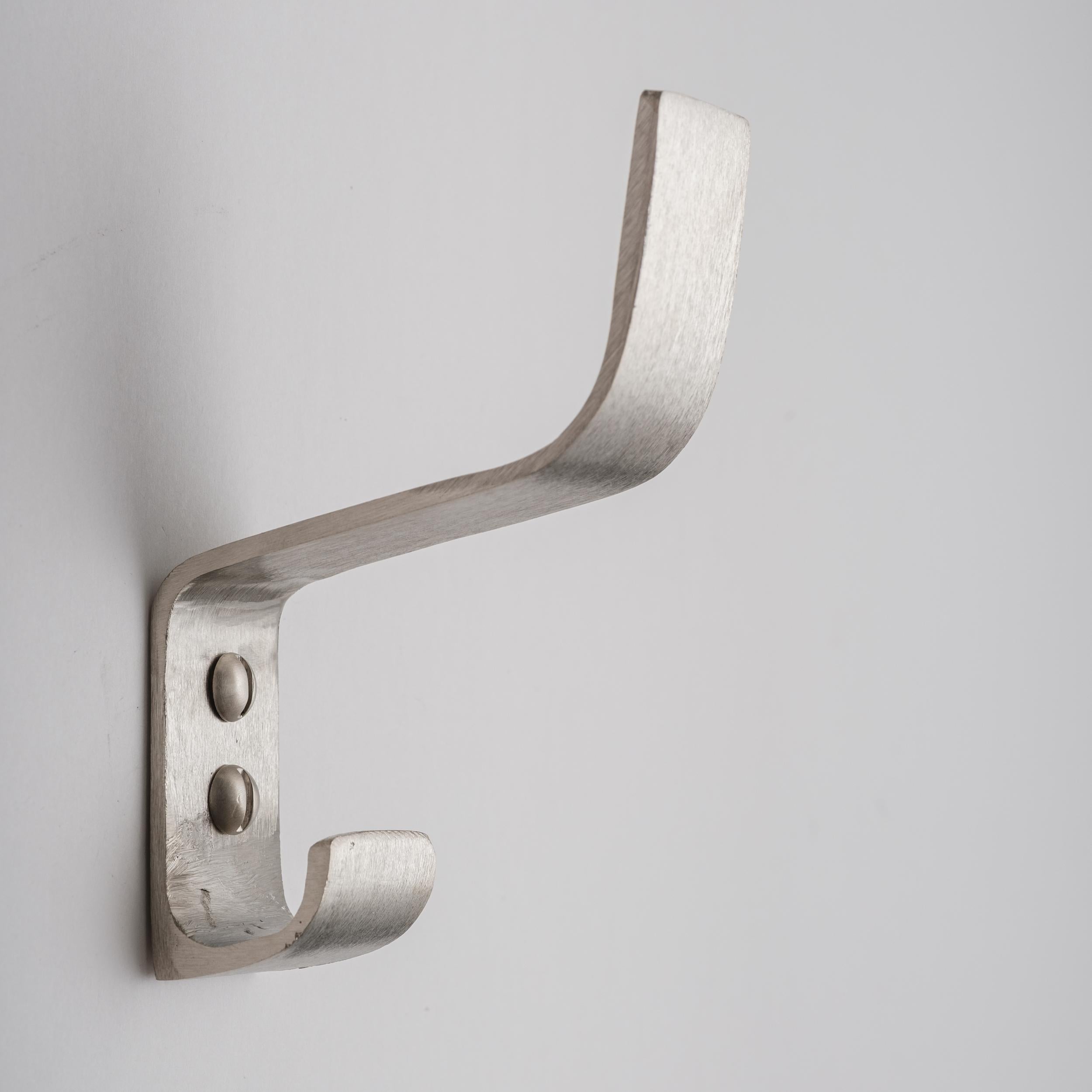 Carl Auböck model #5261 hook in nickel. Designed in the 1950s, this versatile and Minimalist Viennese hook is executed in softly brushed nickel by Werkstätte Carl Auböck, Austria. 

Produced by Carl Auböck IV in the original Auböck workshop in the