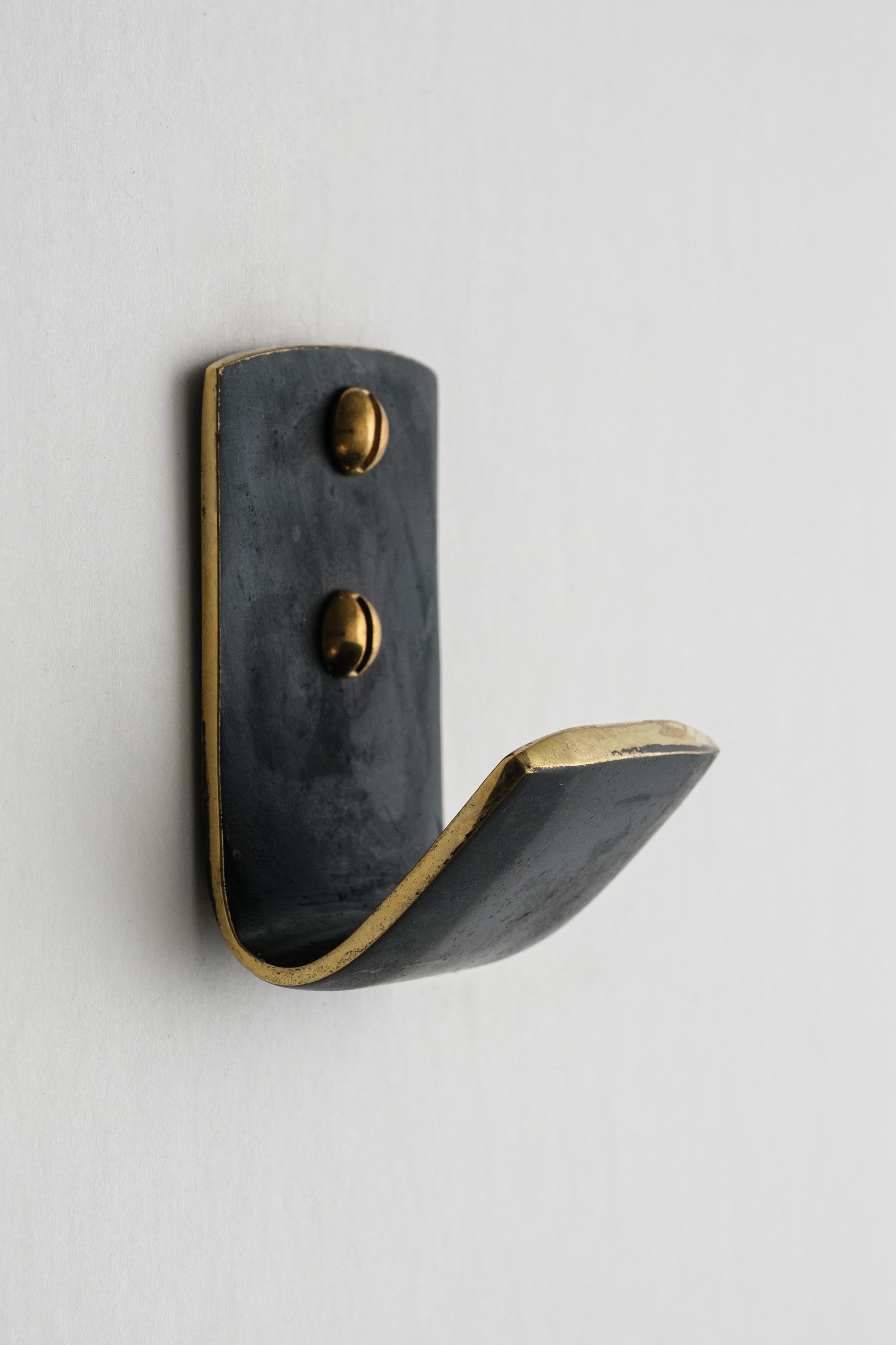 Carl Auböck #5262 patinated brass hook. Designed in the 1950s, this versatile and Minimalist Viennese hook is executed in darkly patinated and polished brass by Werkstätte Carl Auböck, Austria.

Produced by Carl Auböck IV in the original Auböck