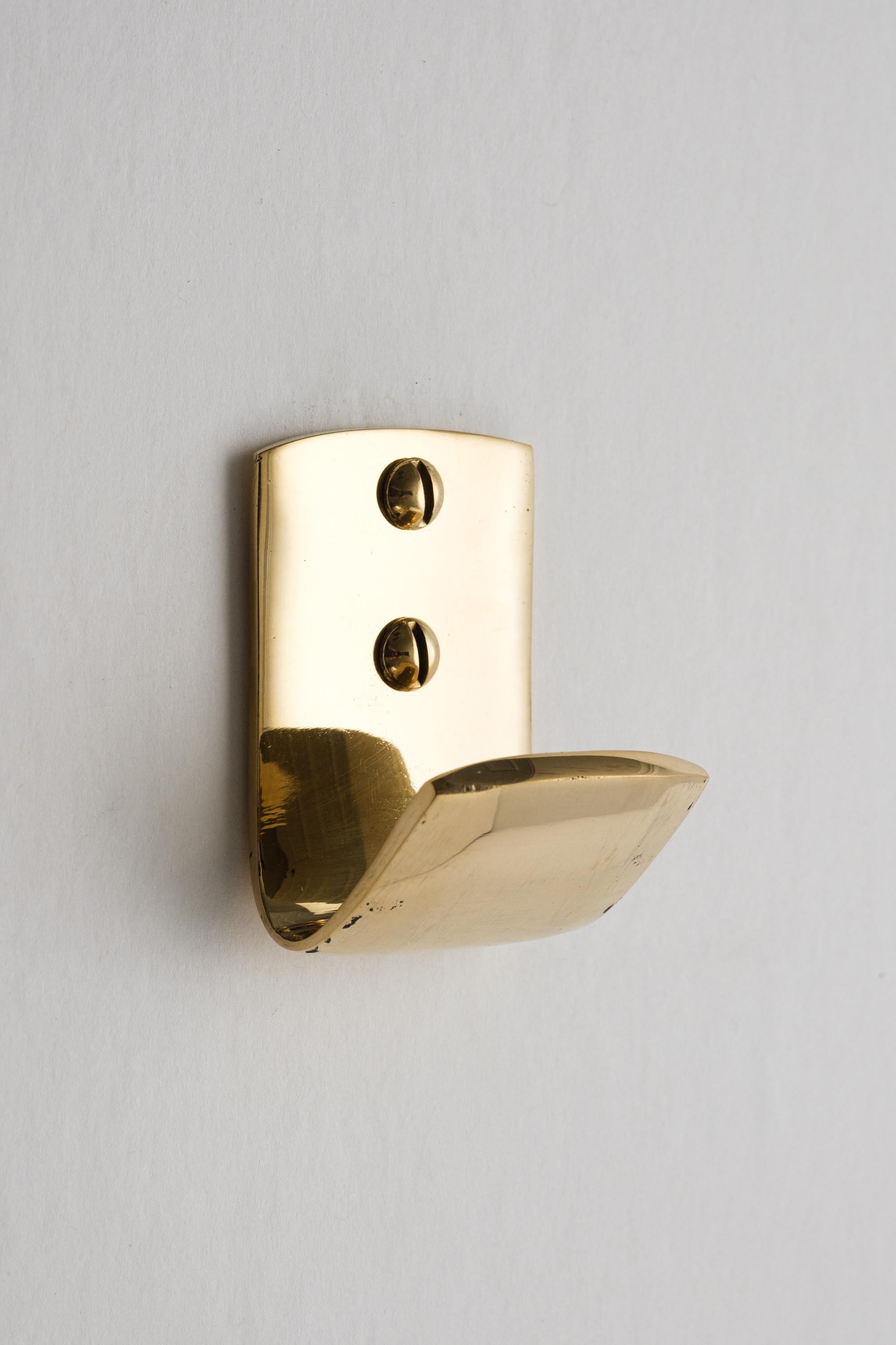 Carl Auböck #5262 polished brass hook. Designed in the 1950s, this versatile and Minimalist Viennese hook is executed in polished brass by Werkstätte Carl Auböck, Austria.

Produced by Carl Auböck IV in the original Auböck workshop in the 7th