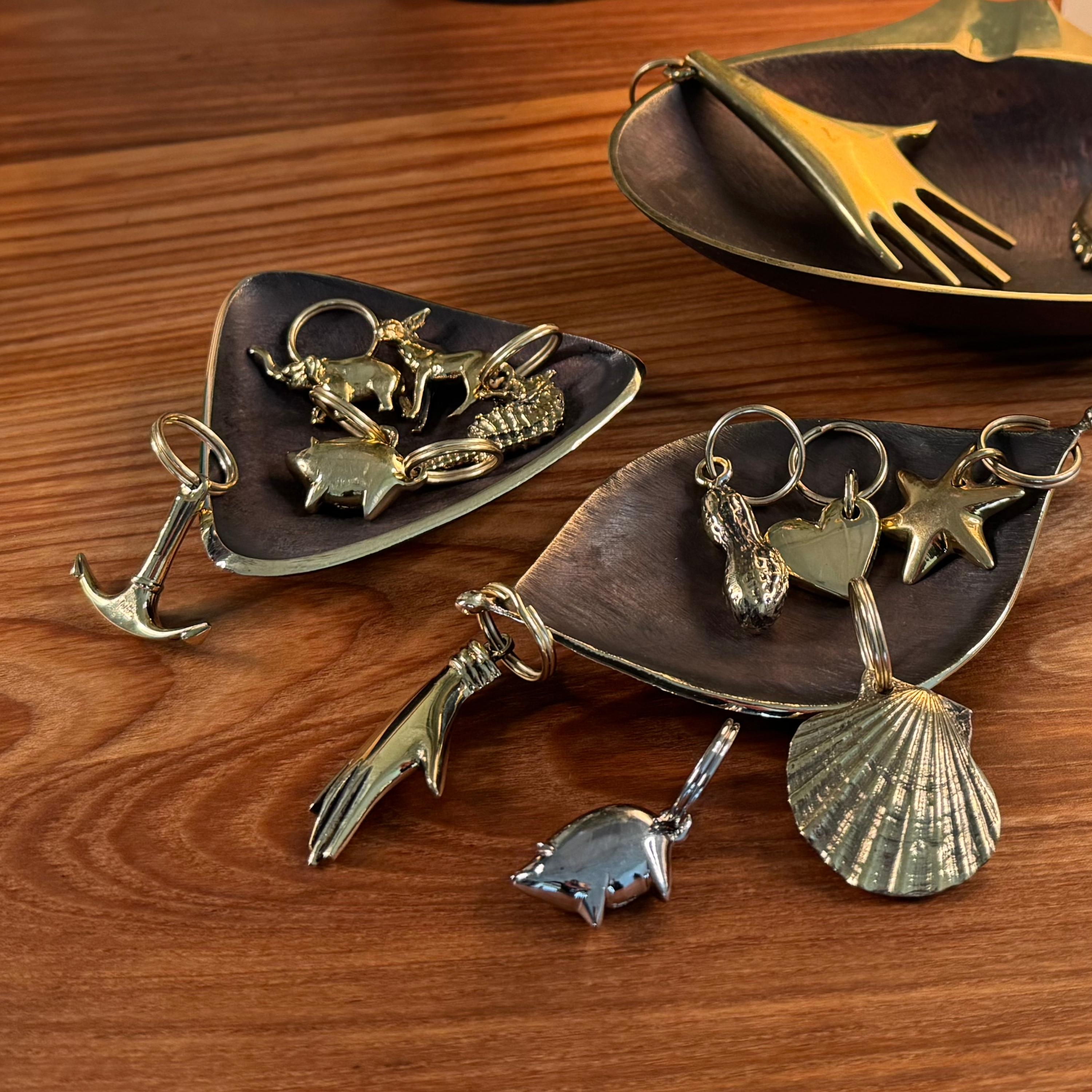 Portachiavi in ottone con statuetta Carl Aubo¨ck modello #5663 'Shell'. Progettato negli anni '50, questo oggetto incredibilmente raffinato e scultoreo è realizzato a mano in ottone lucido.

Il prezzo si intende per articolo. Disponibile in quantità