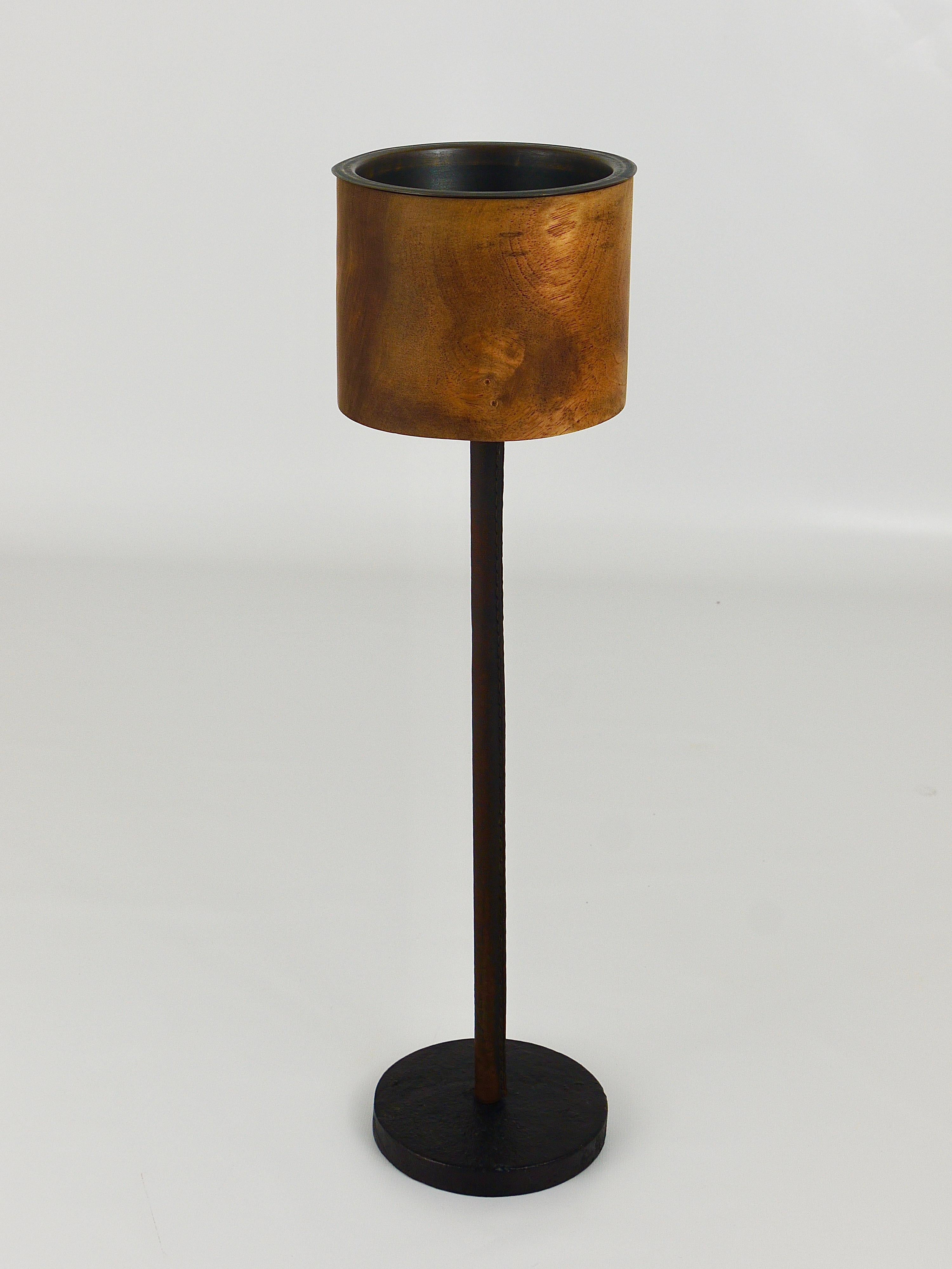A rare midcentury candleholder from the 1950s by Carl Auböck. It is completely handmade and has a cylindrical top, made of walnut with a brass interior on leather covered stem and a black finished cast iron base. In good condition with signs of age