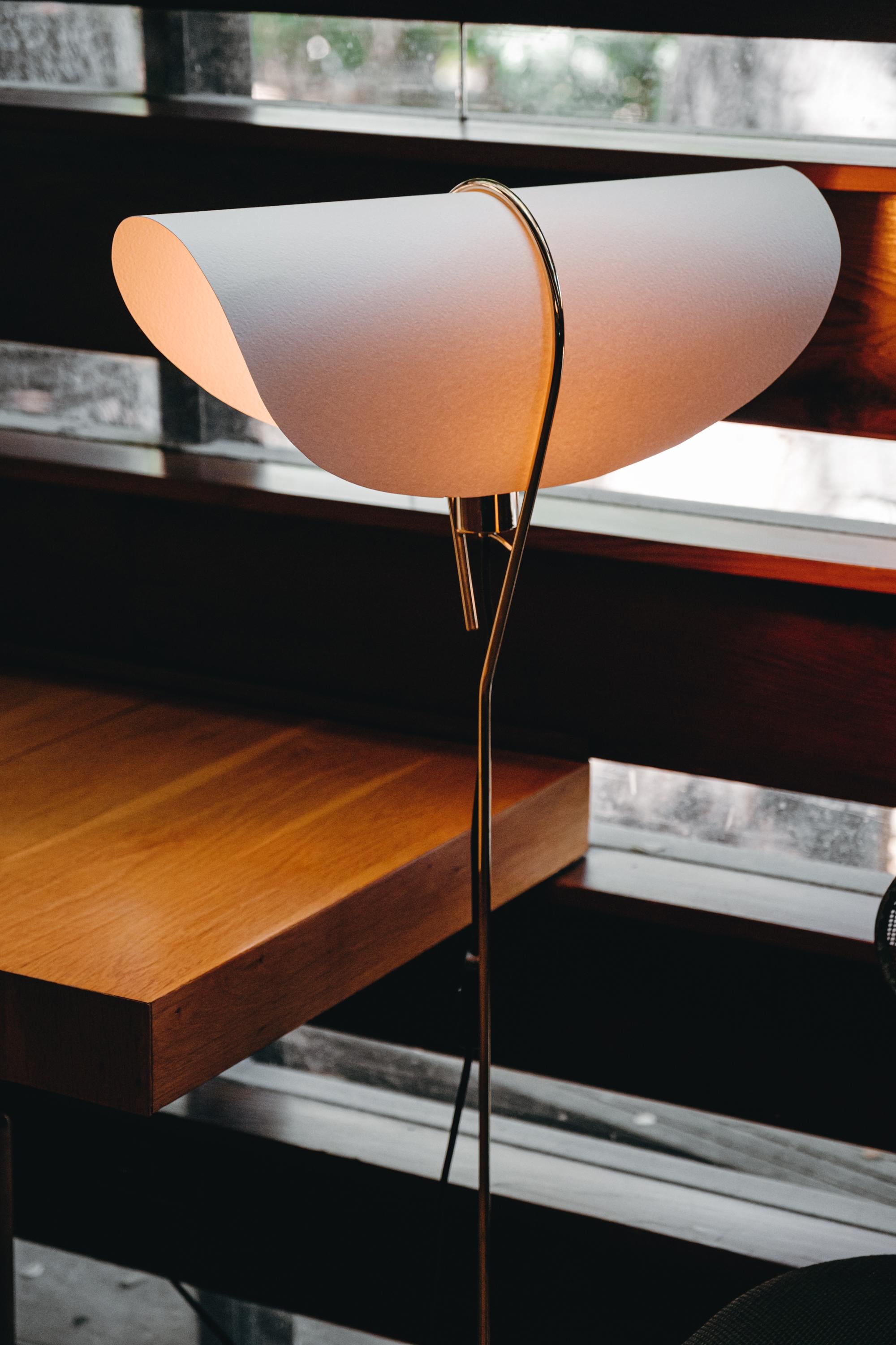 Carl Auböck 'Nun' floor lamp. Designed in 1950, this versatile and Minimalist Viennese lamps is executed in brass with a cast iron base and sculptural hard paper shade by Werkstätte Carl Auböck, Austria. 

Price is per item. One lamp in stock and