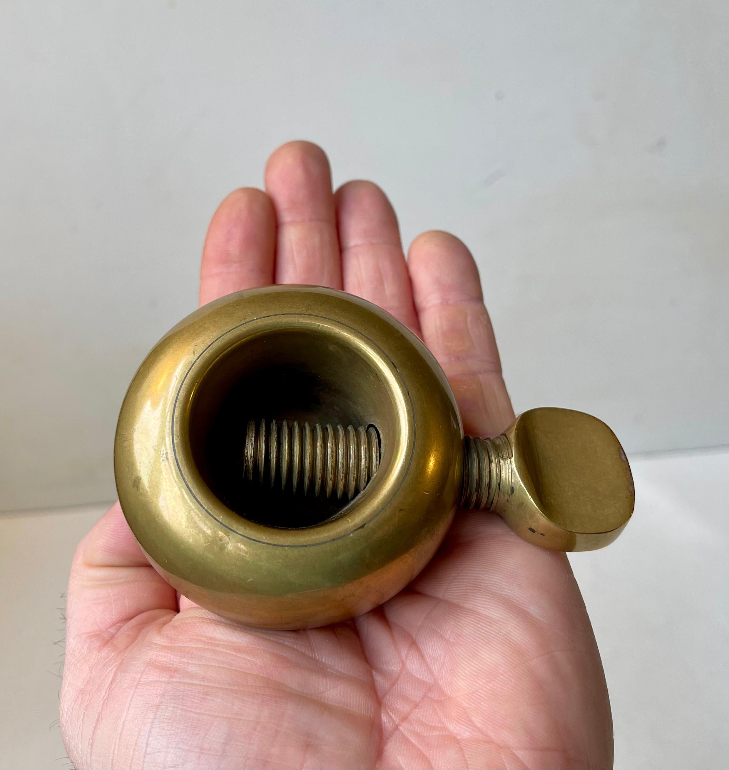 This is not a midcentury torture devise or thumb-screw. But it is indeed a beautifully crafted midcentury nutcracker of the finest quality solid brass. This is the larger version designed by Austrian icon Carl Auböck and made at his own studio
