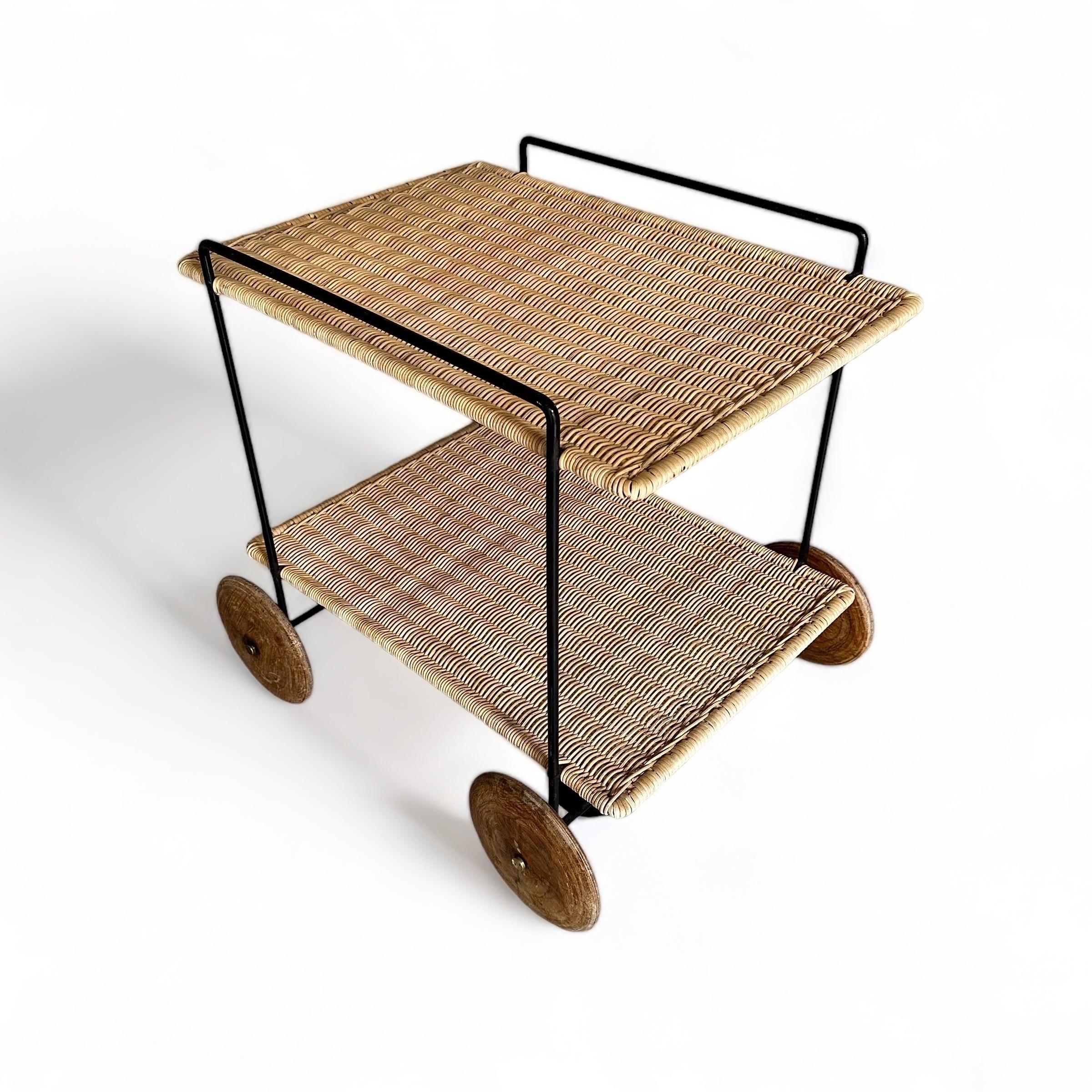 Mid Century Modern vintage organic bar cart or serving trolley by Carl Auböck 1951 and executed by Werkstätte Auböck, Vienna.

While the wonderful serving trolley shows black lacquered round iron frame and two tiers from woven wicker in honey brown