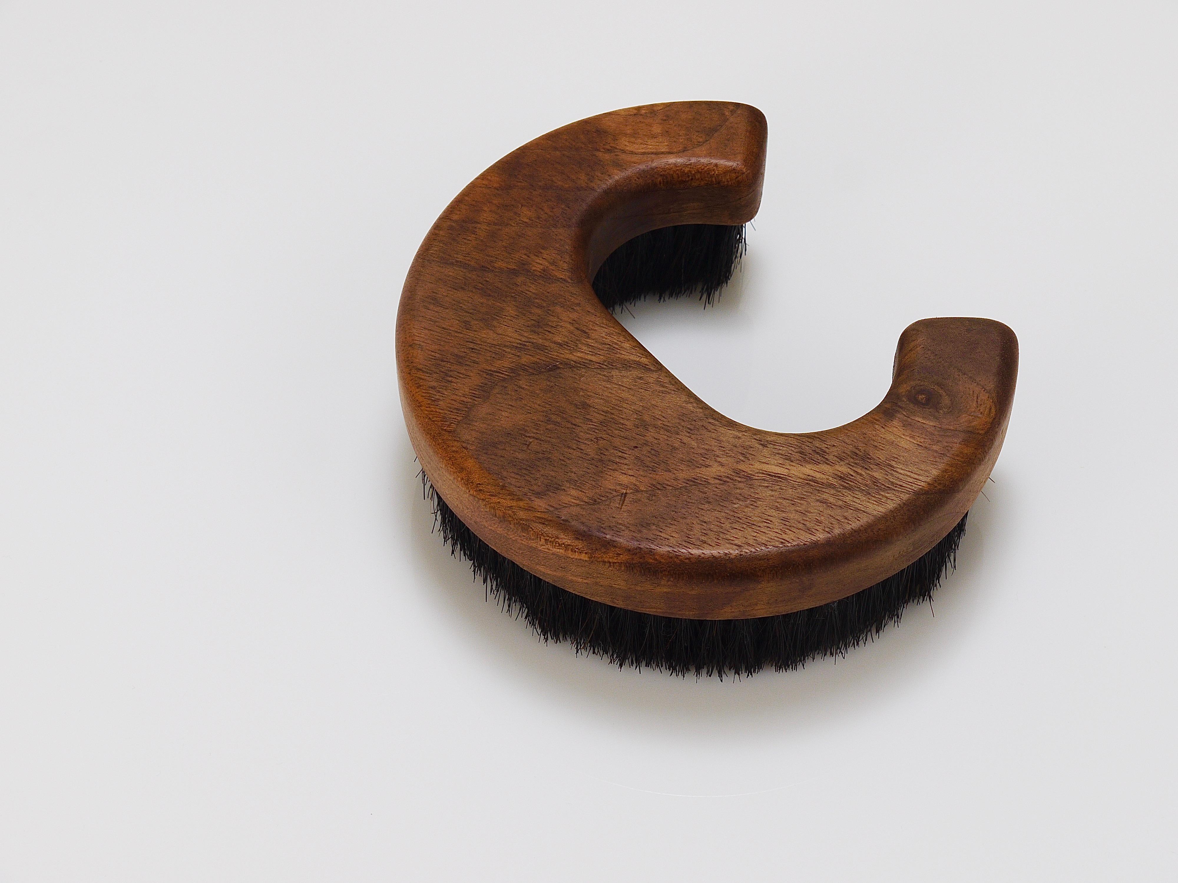 A beautiful modernist clothes or coat brush in the shape of the letter C from the 1960s. Designed and executed by Carl Aubock III, Vienna/Austria. Handmade of walnut and natural horse hair bristles. Signed in the wood. In very good condition.