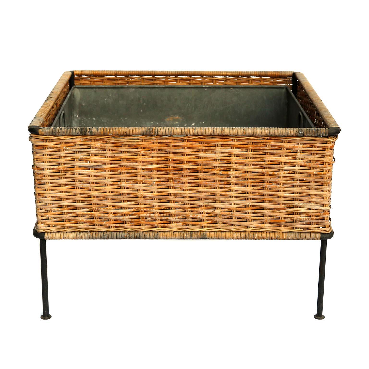 A planter with the original cane, wicker, and internal liner in zinc and a black painted metal frame designed by Carl Auböck, manufactured by Carl Auböck workshop in midcentury, circa 1950.
The aged cane and wicker is in good condition. The liner