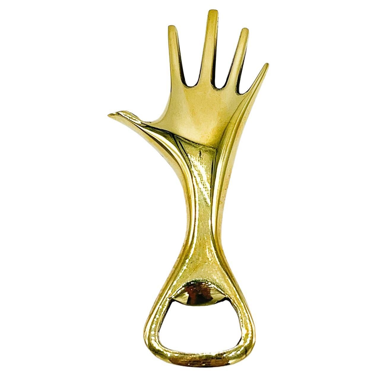 Carl Aubock polished brass hand bottle opener #4224. This whimsical 1950's hand bottle opener by Carl Aubock is a wonderful example of the marriage of form and functionality that has made the Aubock name synonymous with great design. Aubock items