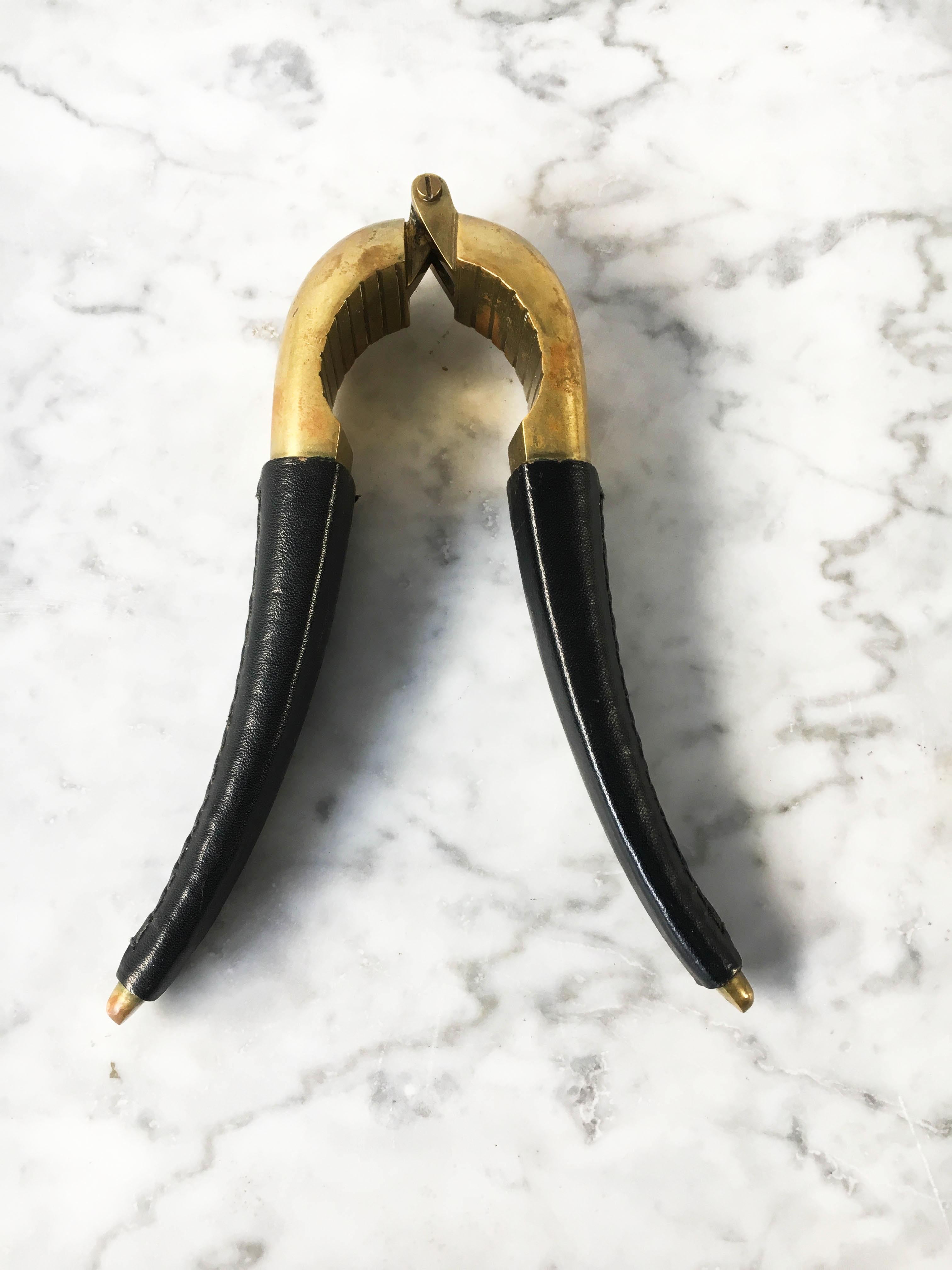 A beautiful sculptural nutcracker, model 4051, designed 1942 by Carl Auböck. Cast brass, the handle is covered by black leather. In excellent vintage condition with just the right amount of gently aged patina on the brass and leather.
 