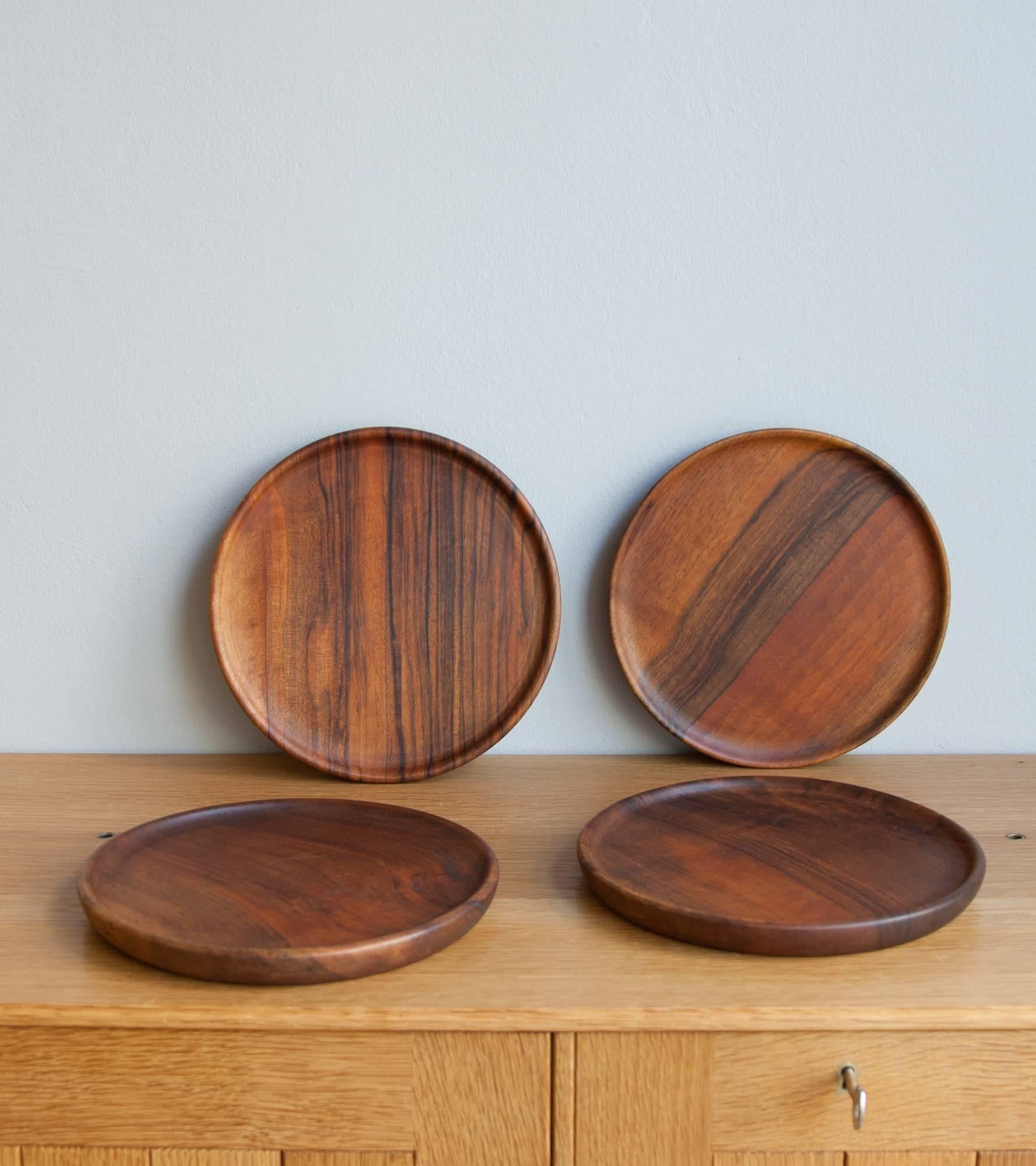 Vintage set of four wooden plates by the Auböck Werkstätte, Vienna, circa 1970.
Minimal in shape, each plate is hand-carved out of walnut has a shallow lip and a circular cavity on the underside. One of four bears the 'Auböck' mark.
With signs of
