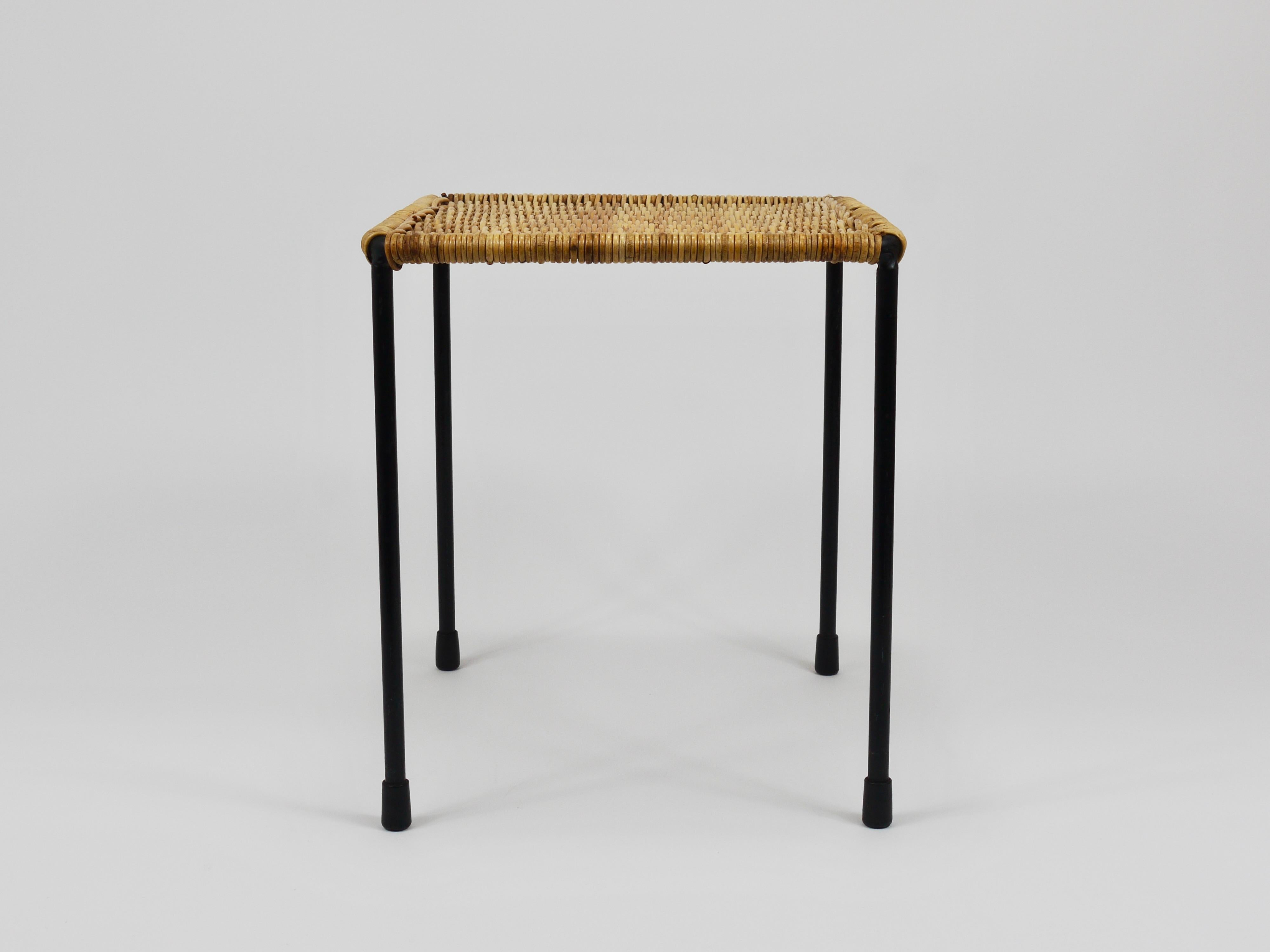 A beautiful square organic Mid-Century side or plant table / stool from the 1950s. This authentic vintage minimalistic piece was designed and crafted by Werkstätte Carl Auböck, hand-woven from wicker. It features a black-finished iron frame with a