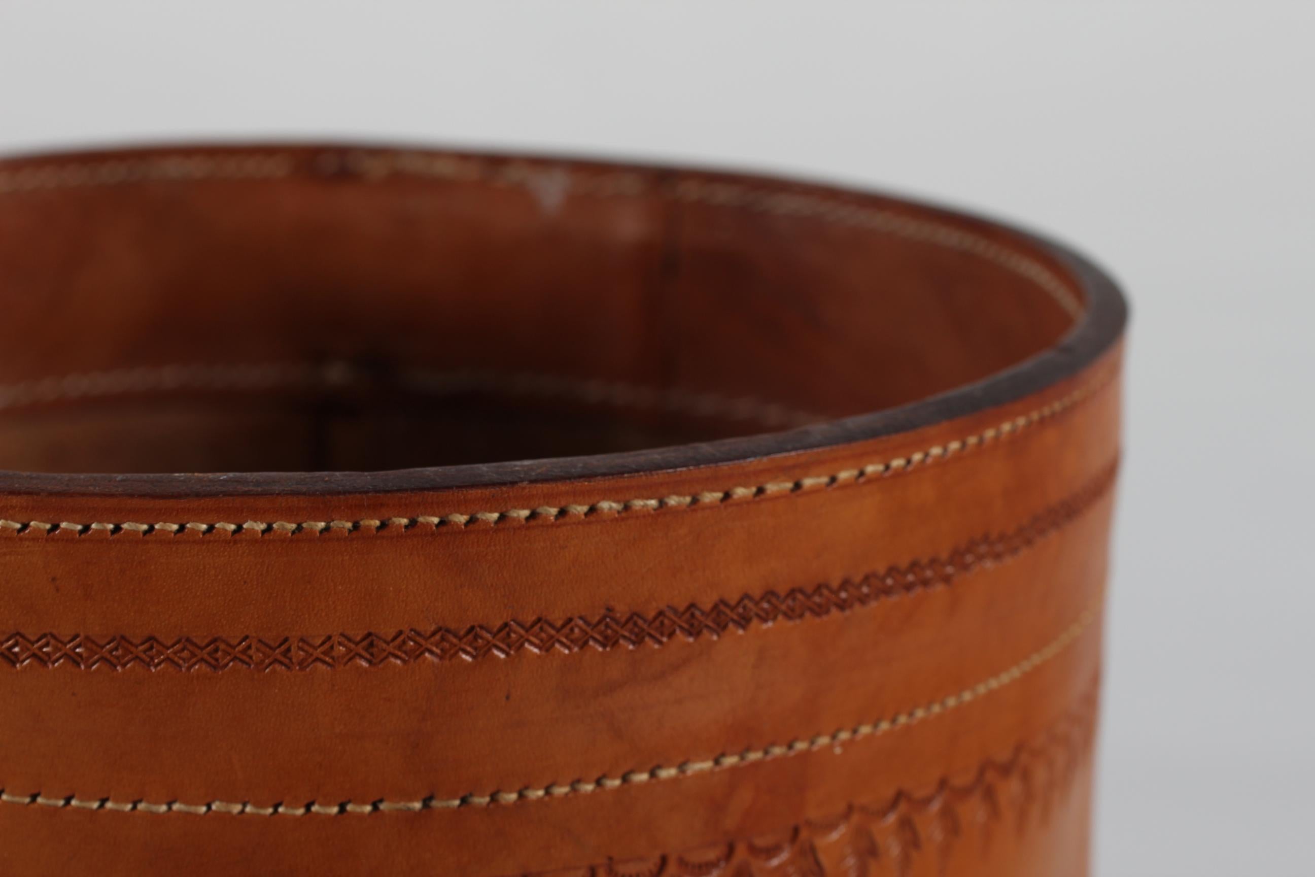 Round European vintage wastepaper basket from the 1970s.
It's made of strong genuine cognac colored core leather with incised pattern and visible stitching 
It remains in very good condition with a beautiful patina.
     