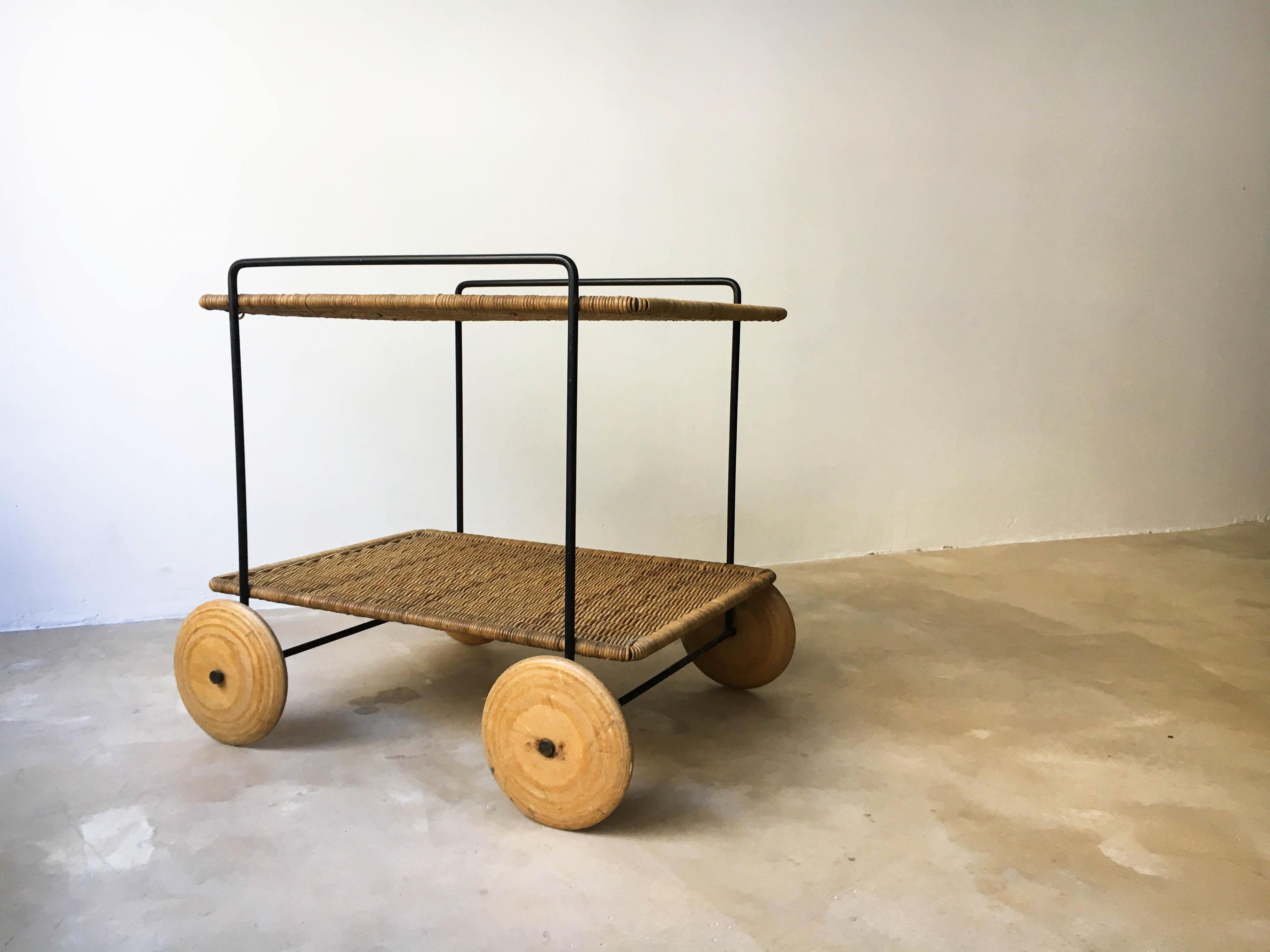 An iron frame and woven rattan server or trolley with wood wheels. A rare and early example of designer Carl Auböck. Very good vintage condition with lovely patina.