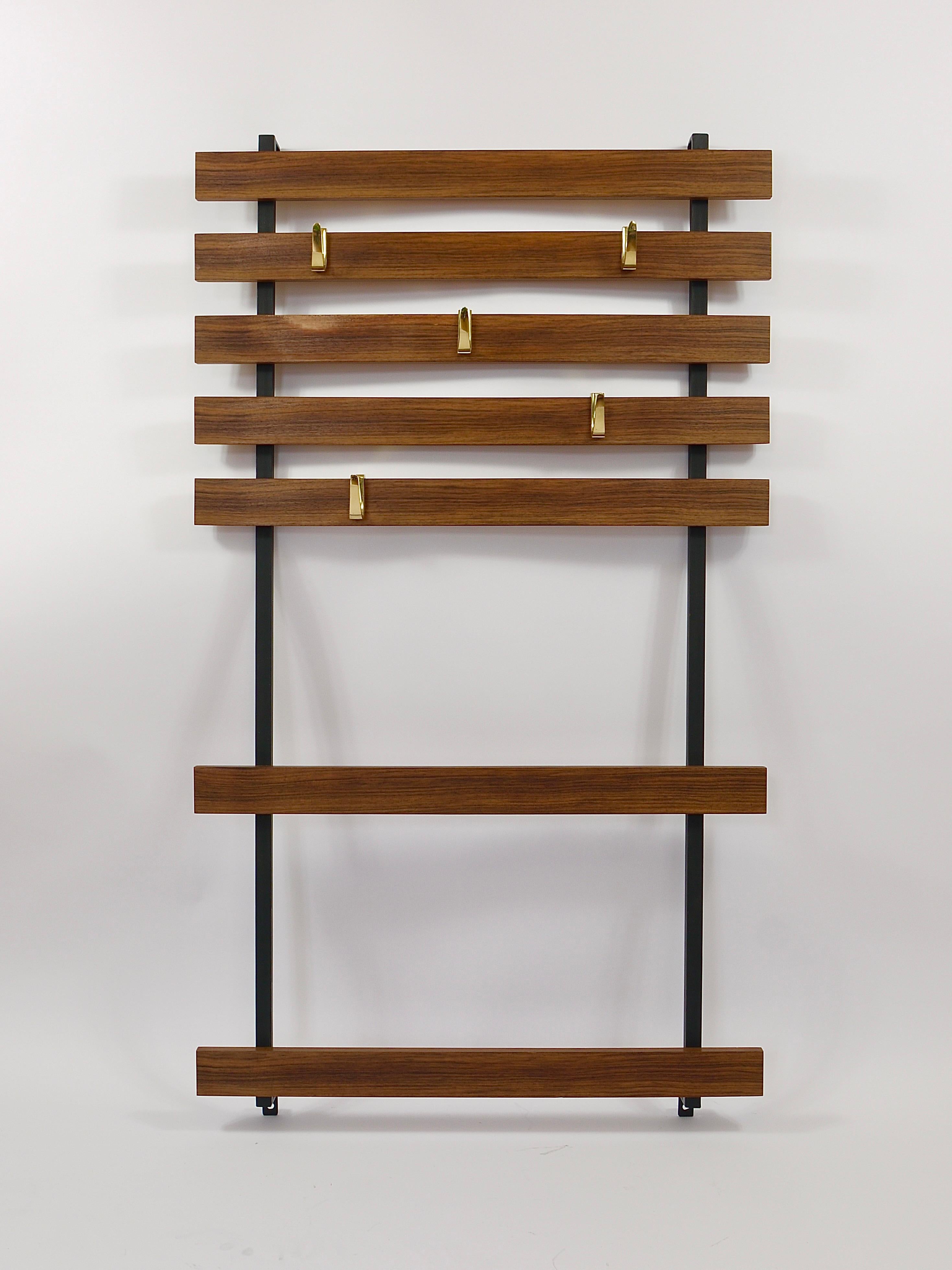 A Minimalist Mid Century modern wall-mounted coat rack, equipped with five „5“-shaped polished solid brass wall hooks. This is an early model from the early 1950s, designed and executed by Werkstätte Carl Aubock in Vienna Austria. Consist of a black