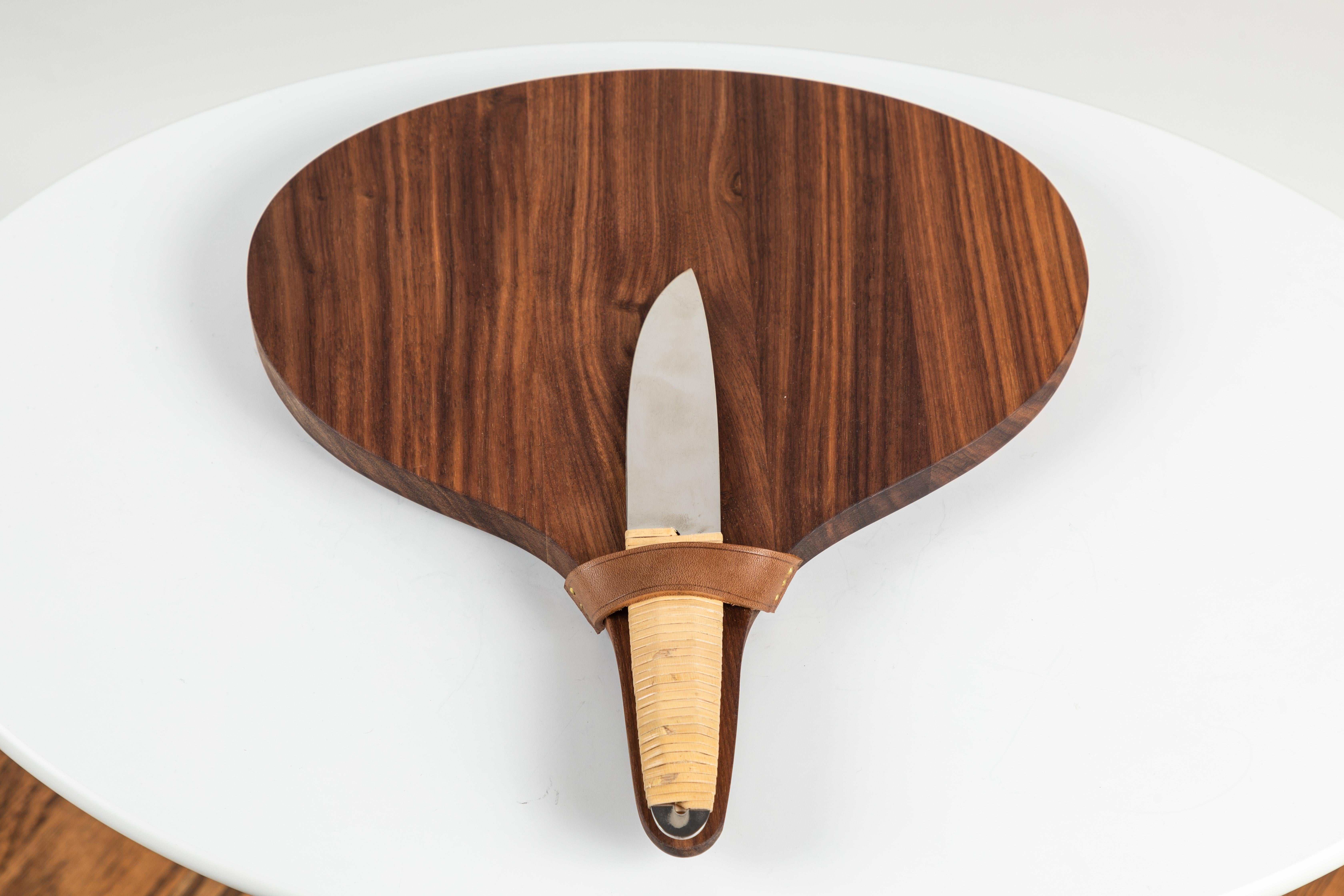 Carl Auböck walnut board and cheese knife. Designed in the 1950s, this incredibly refined and sculptural set includes one model #4363 serving or cutting board executed in beautifully grained walnut and leather and one model #4828 knife executed in