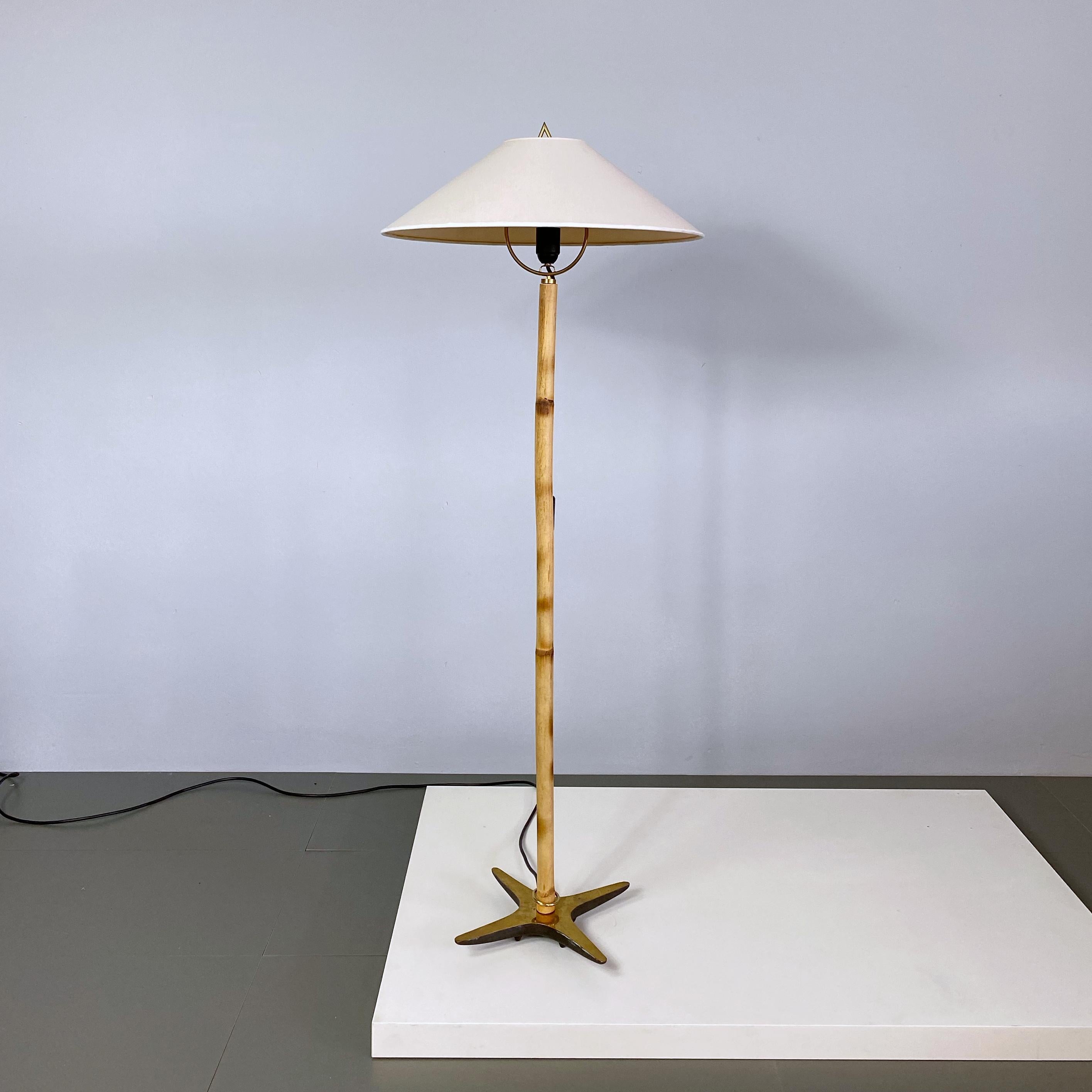 Simple and elegant midcentury floor lamp designed by Carl Auböck and manufactured by Werkstätten Carl Auböck in Vienna. The lamp is made of a bamboo stick with a solid brass X-base which is heavy enough to allow it to tilt sideways, to have the